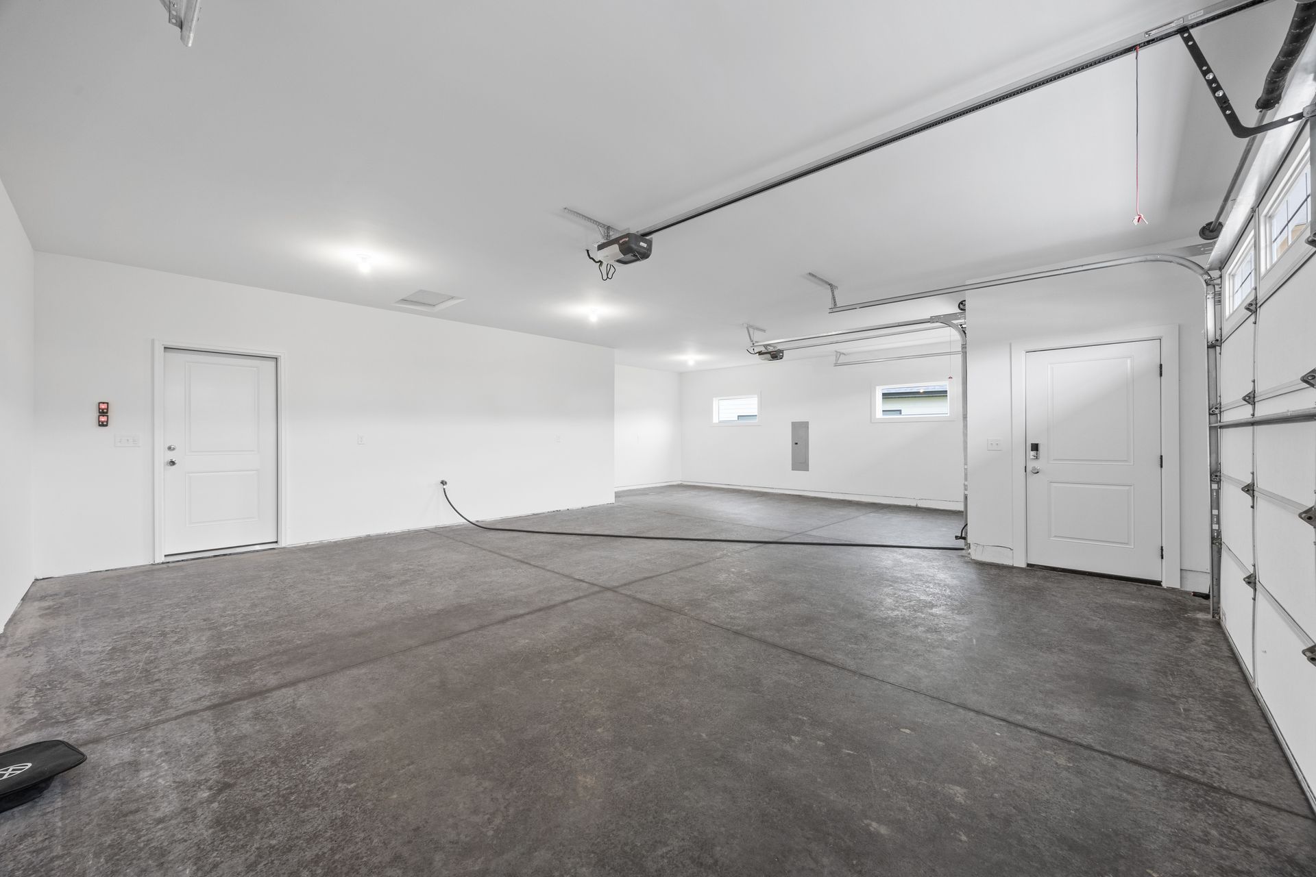 An empty garage with a black floor and white walls.