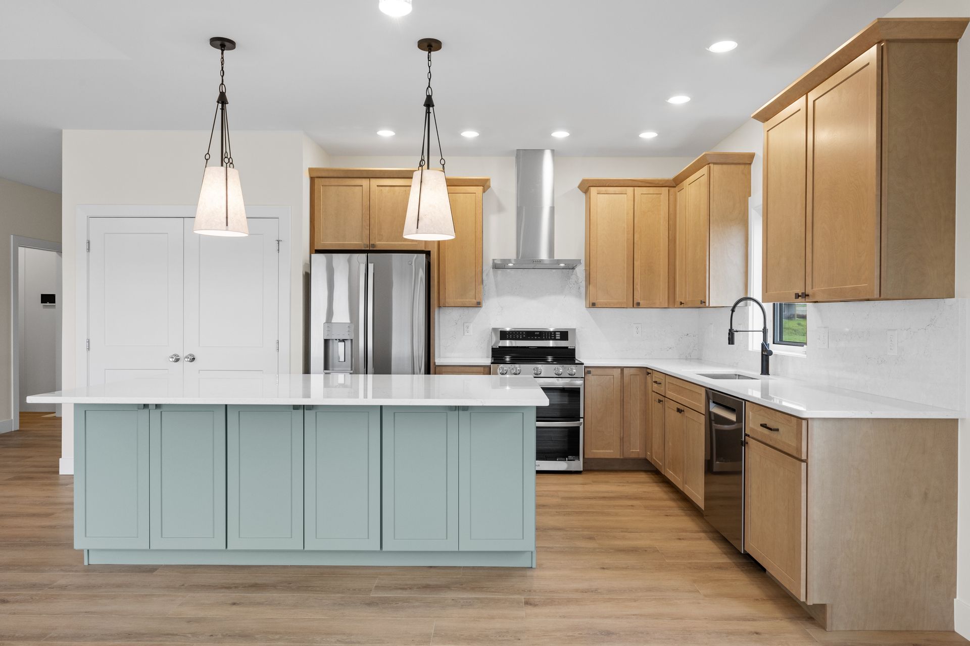A kitchen with a large island and stainless steel appliances
