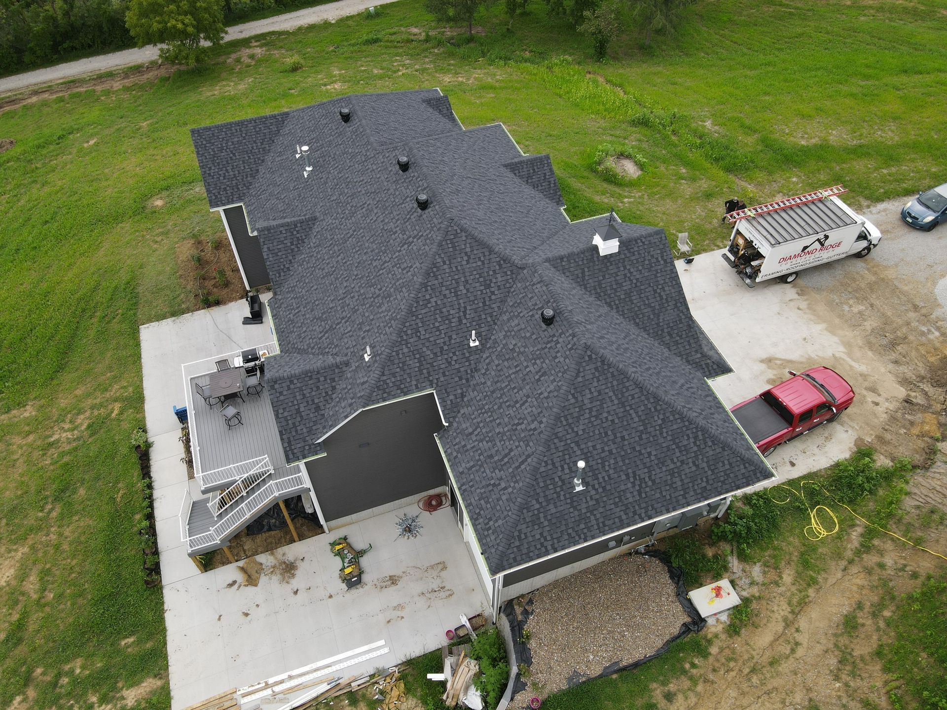 An aerial view of a house under construction with a truck parked in front of it.