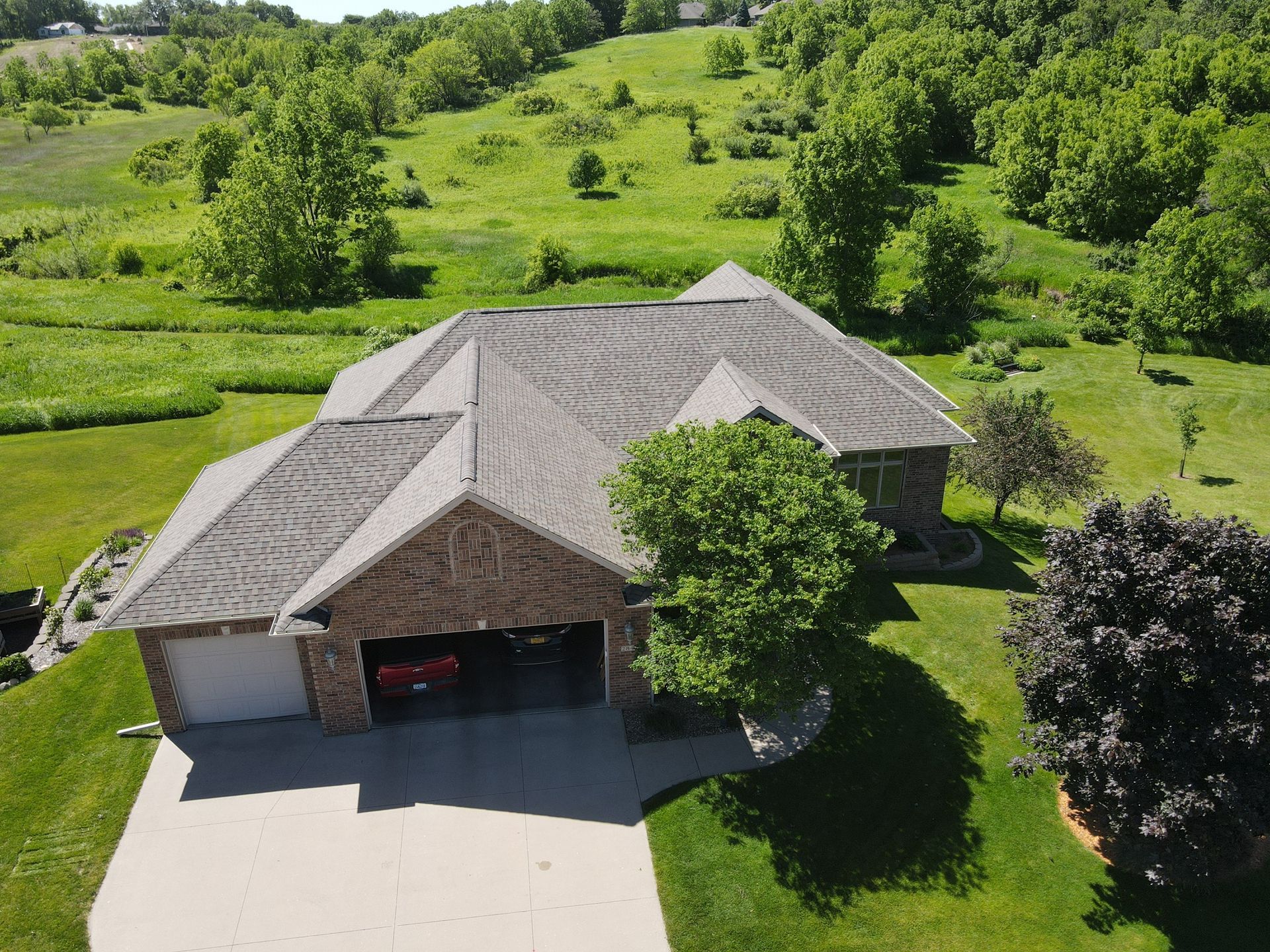 An aerial view of a house with a red truck parked in the driveway.