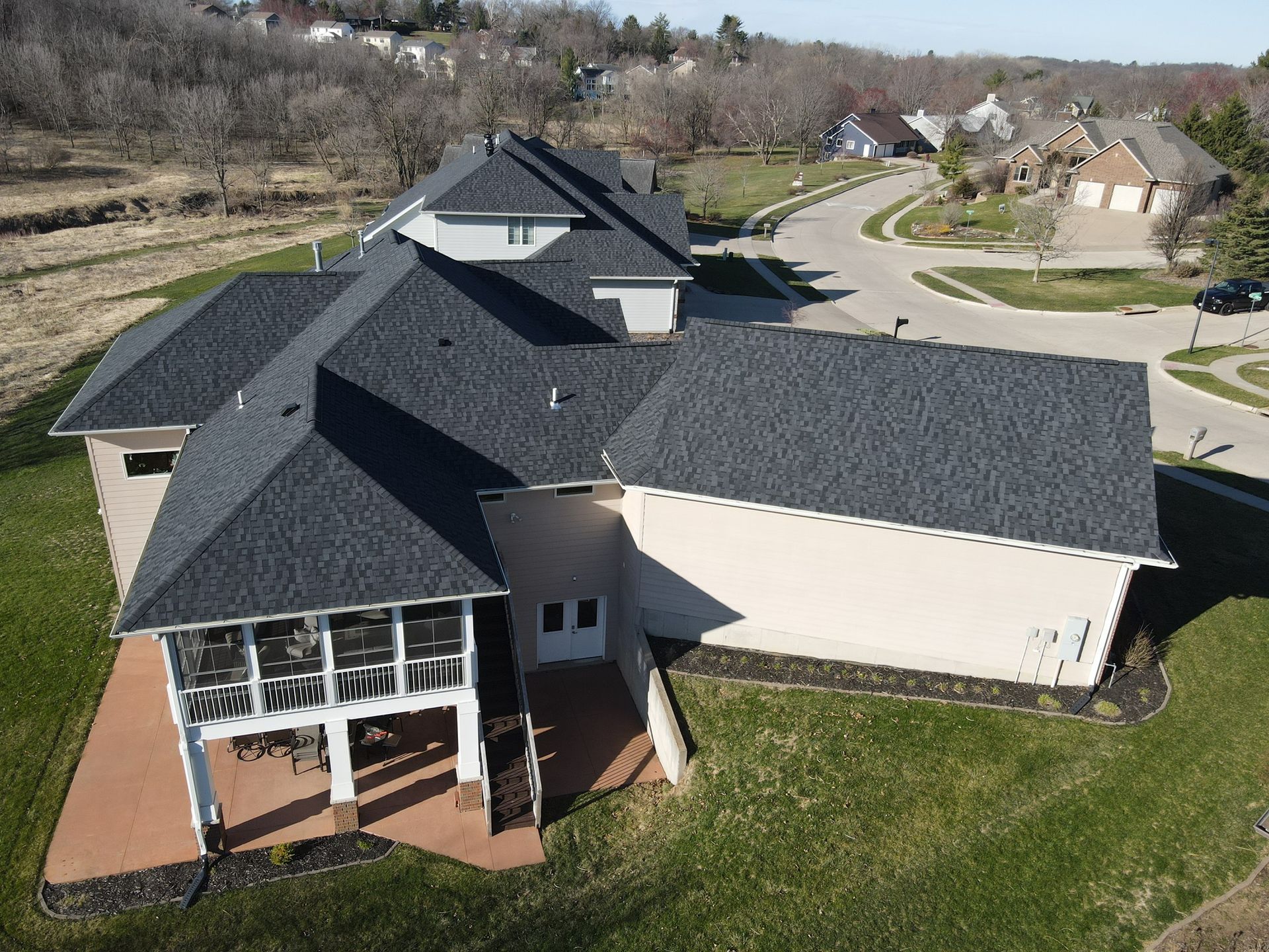 An aerial view of a large house with a black roof