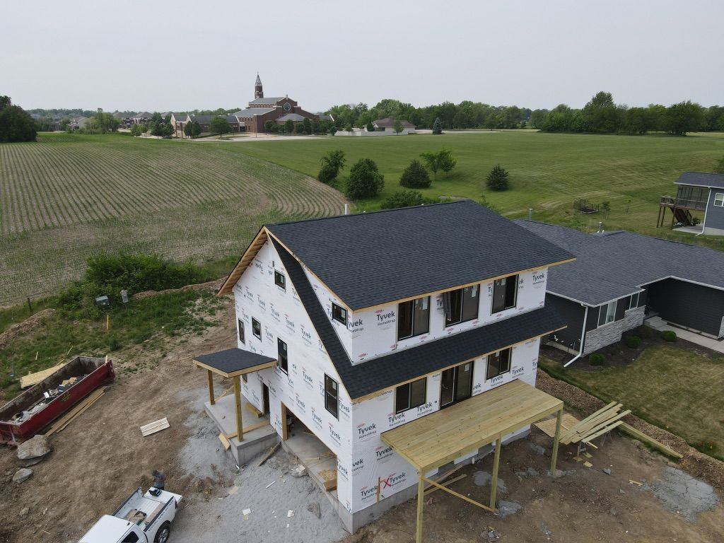 An aerial view of a house under construction in a field.