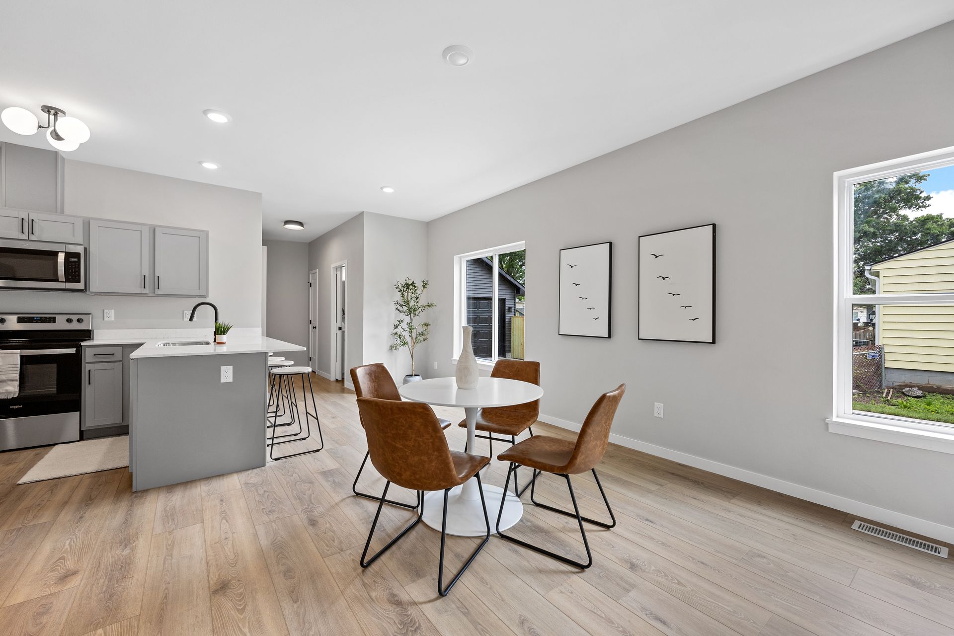 A living room with a table and chairs and a window.