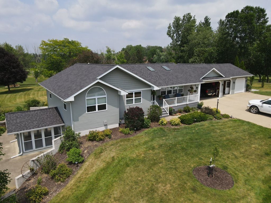 An aerial view of a house with a car parked in front of it
