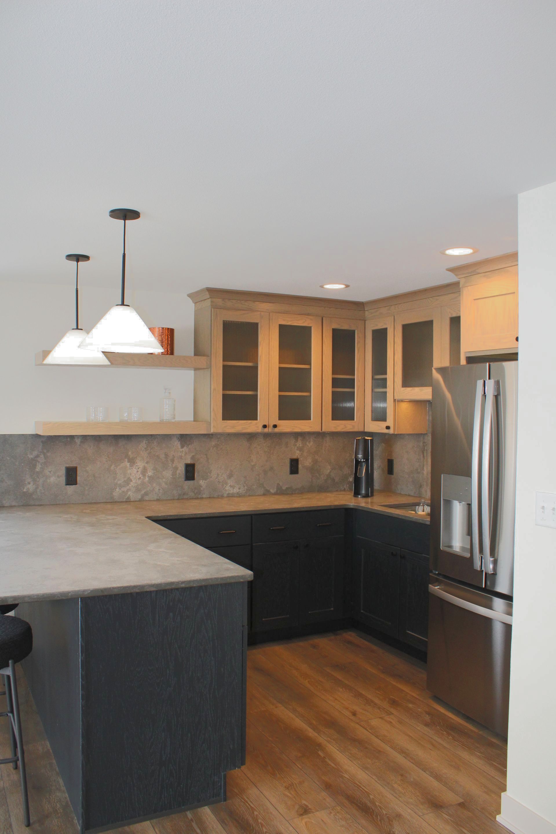 A kitchen with black cabinets and stainless steel appliances