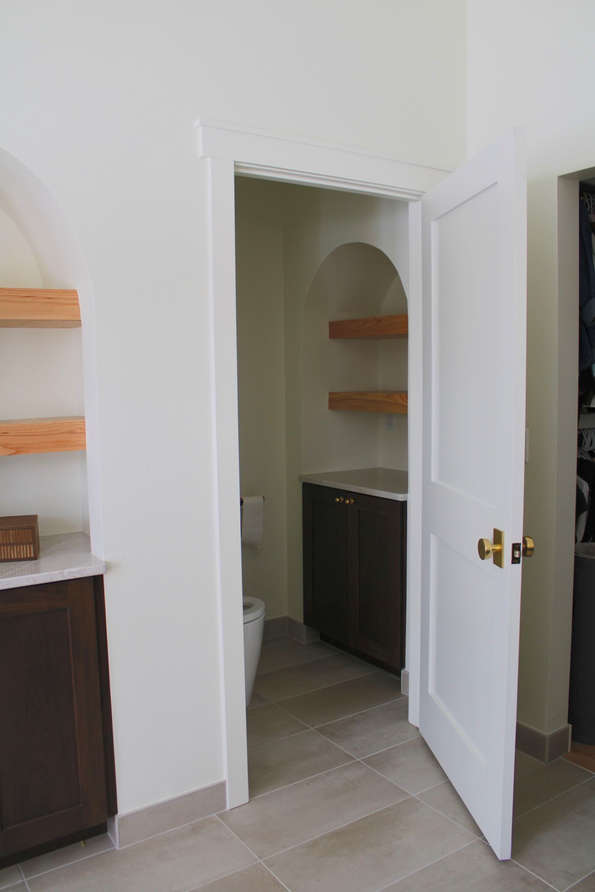 A white door is open to a bathroom with a toilet.