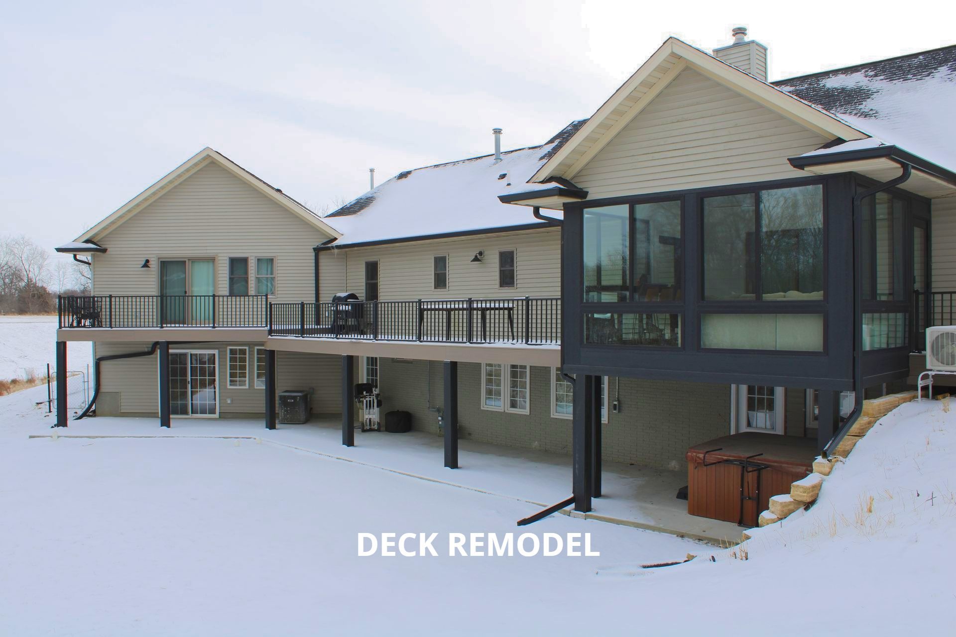 A large house with a deck remodel and a hot tub