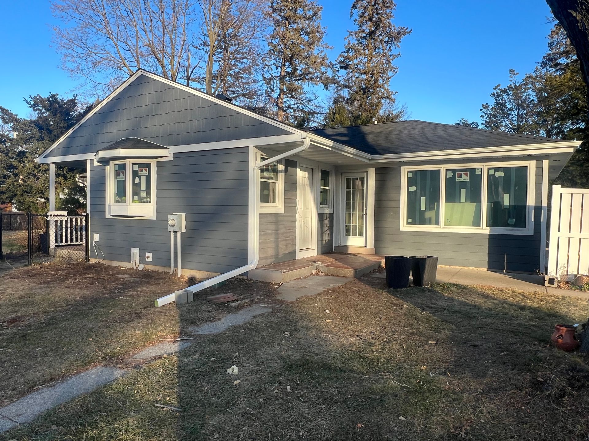 A house with a blue siding and white trim is for sale.
