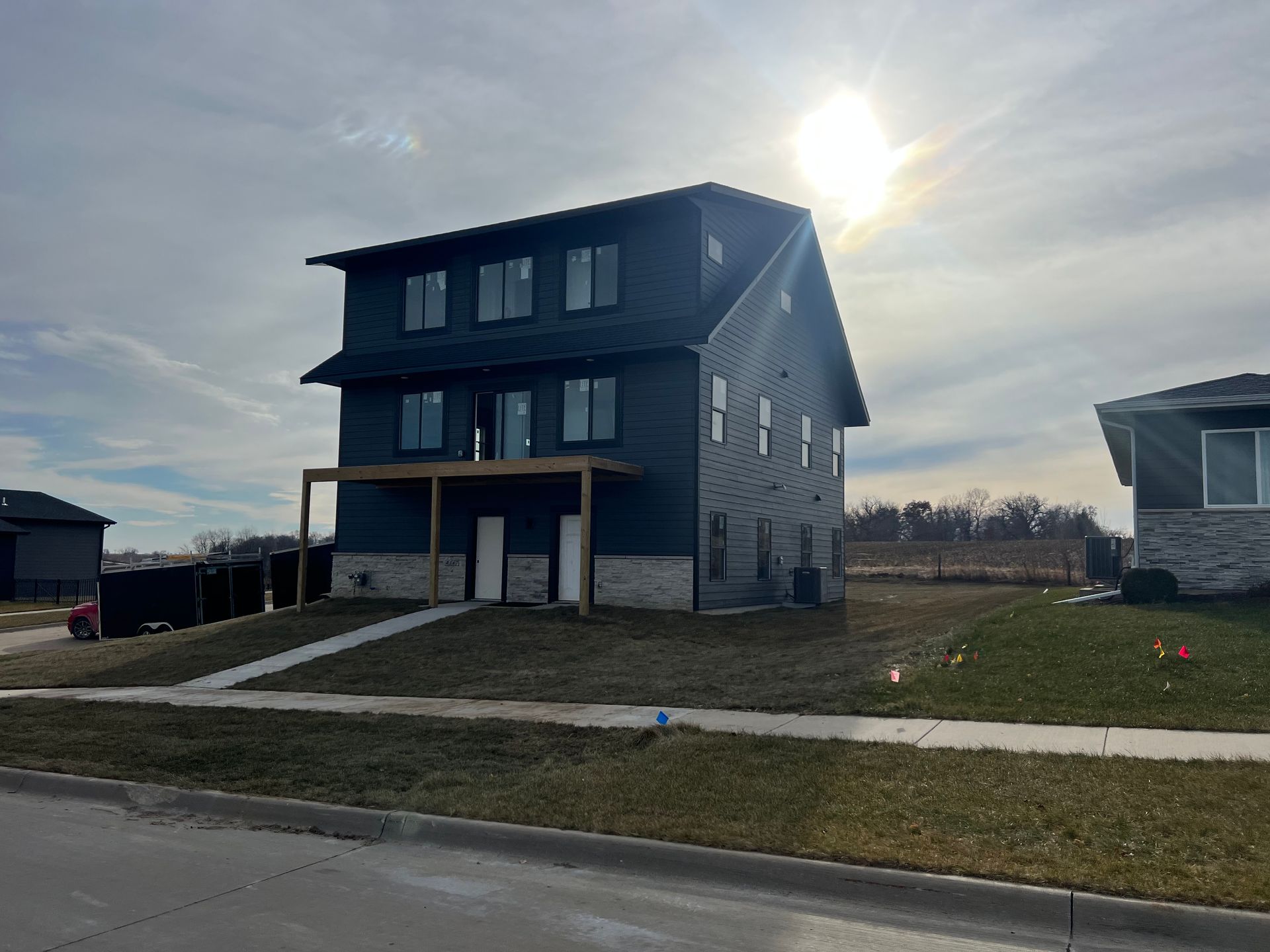 A large house with a lot of windows is sitting on top of a grassy hill.
