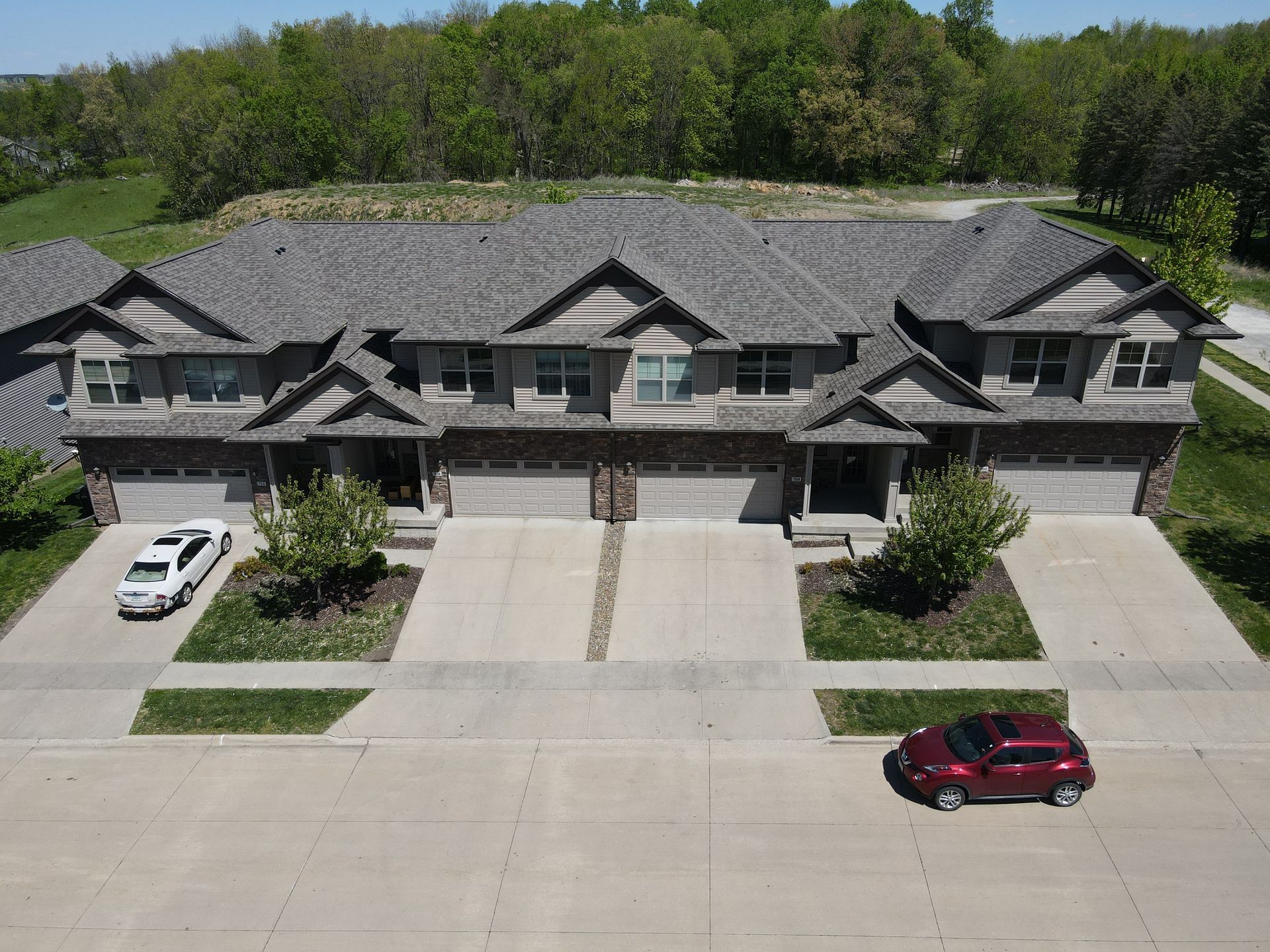 An aerial view of a row of houses with cars parked in front of them.