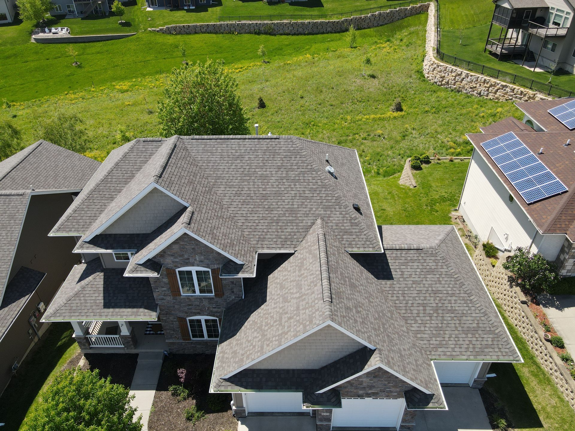 An aerial view of a large house with solar panels on the roof.