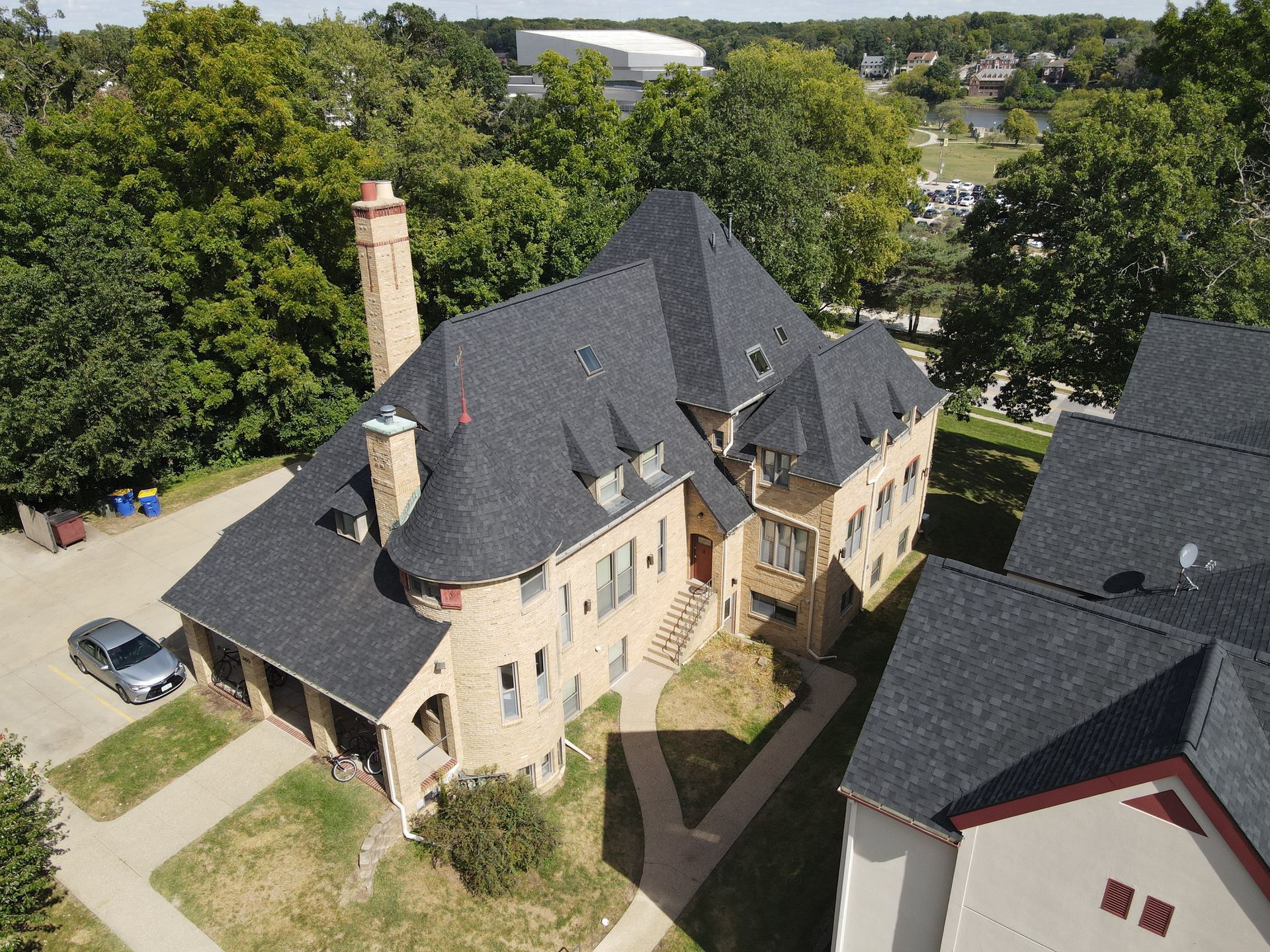 An aerial view of a large house with a black roof