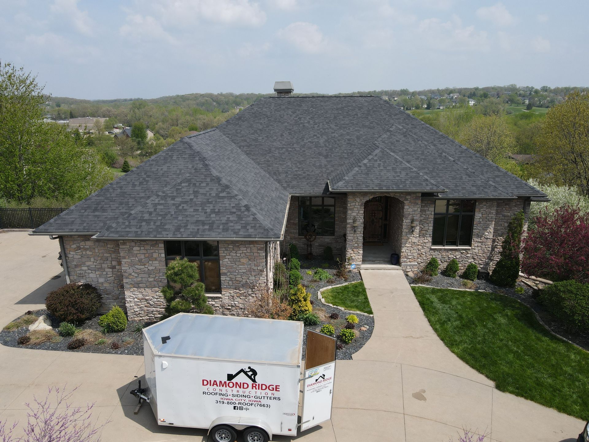 An aerial view of a house with a trailer parked in front of it.