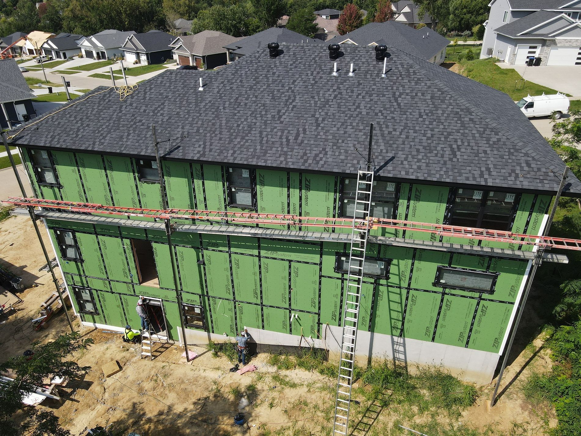An aerial view of a house under construction in a residential area.