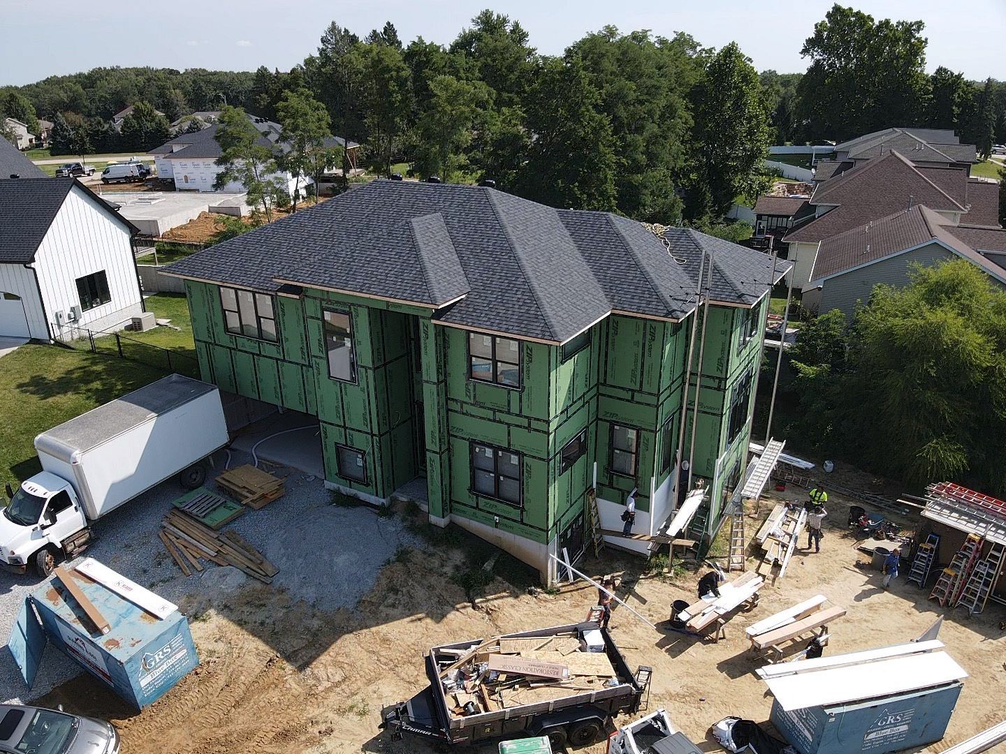 An aerial view of a house under construction in a residential area.
