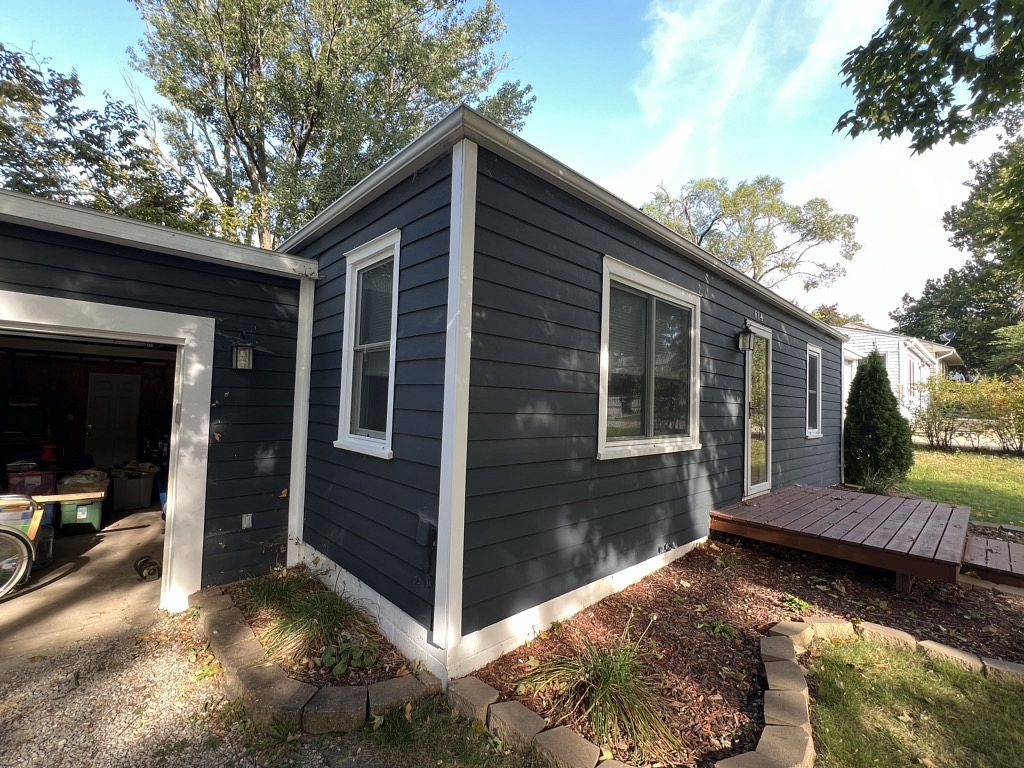 A small house with a garage and a deck in the backyard.