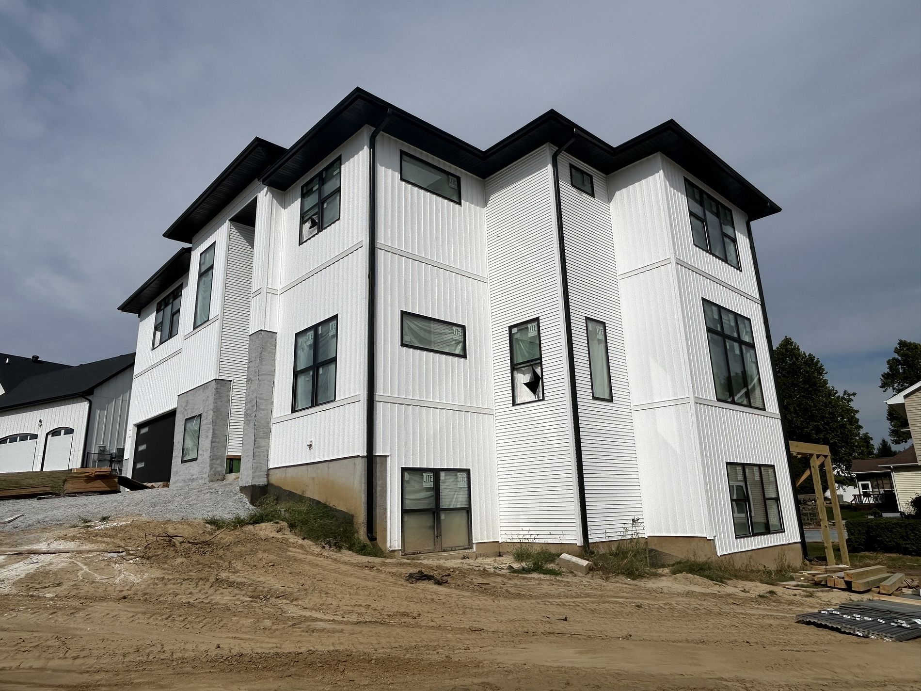 A large white building with a lot of windows is sitting on top of a dirt hill.