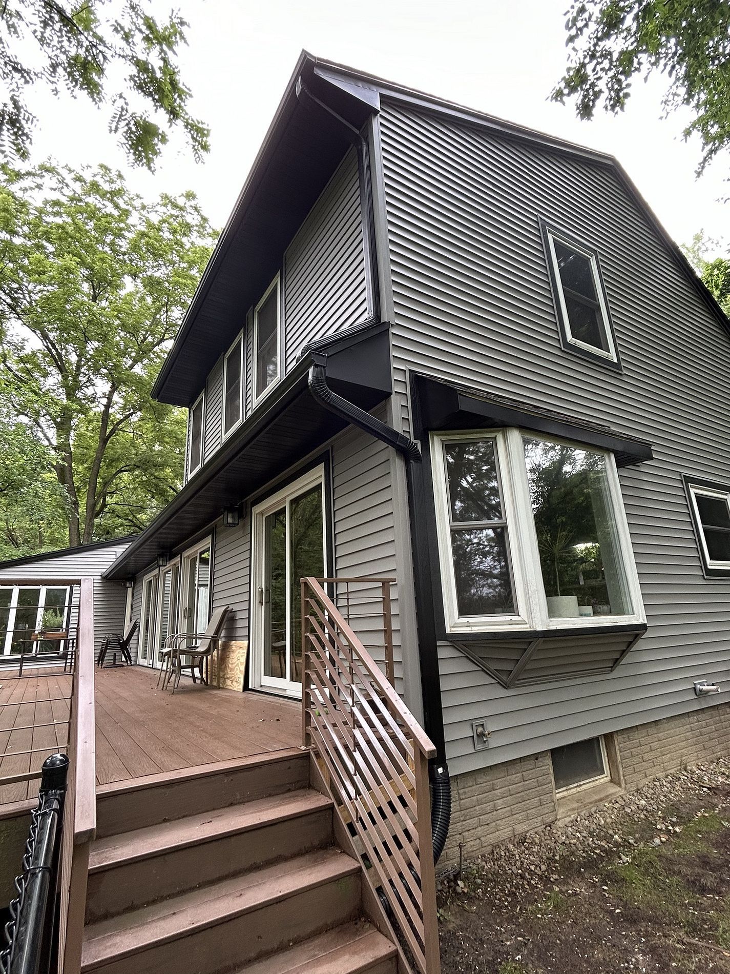 A large house with a large deck and stairs leading up to it.
