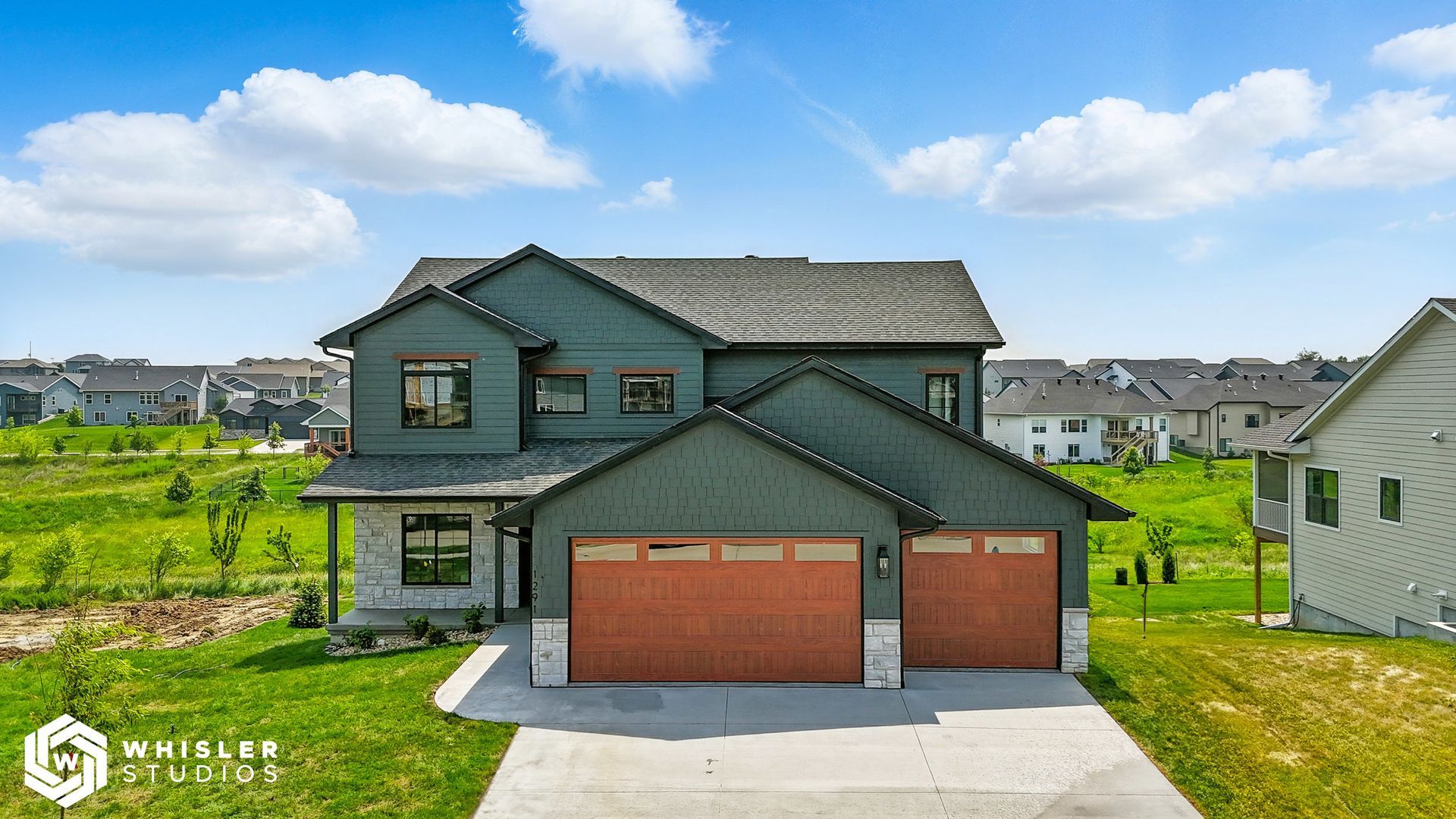 An aerial view of a large house with two garage doors in a residential area.