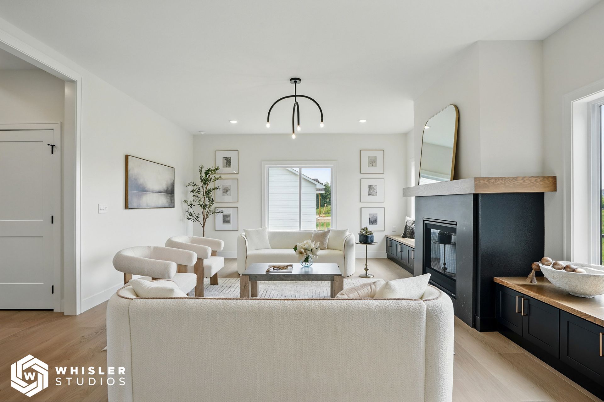 A living room with a couch, chairs, coffee table and fireplace.
