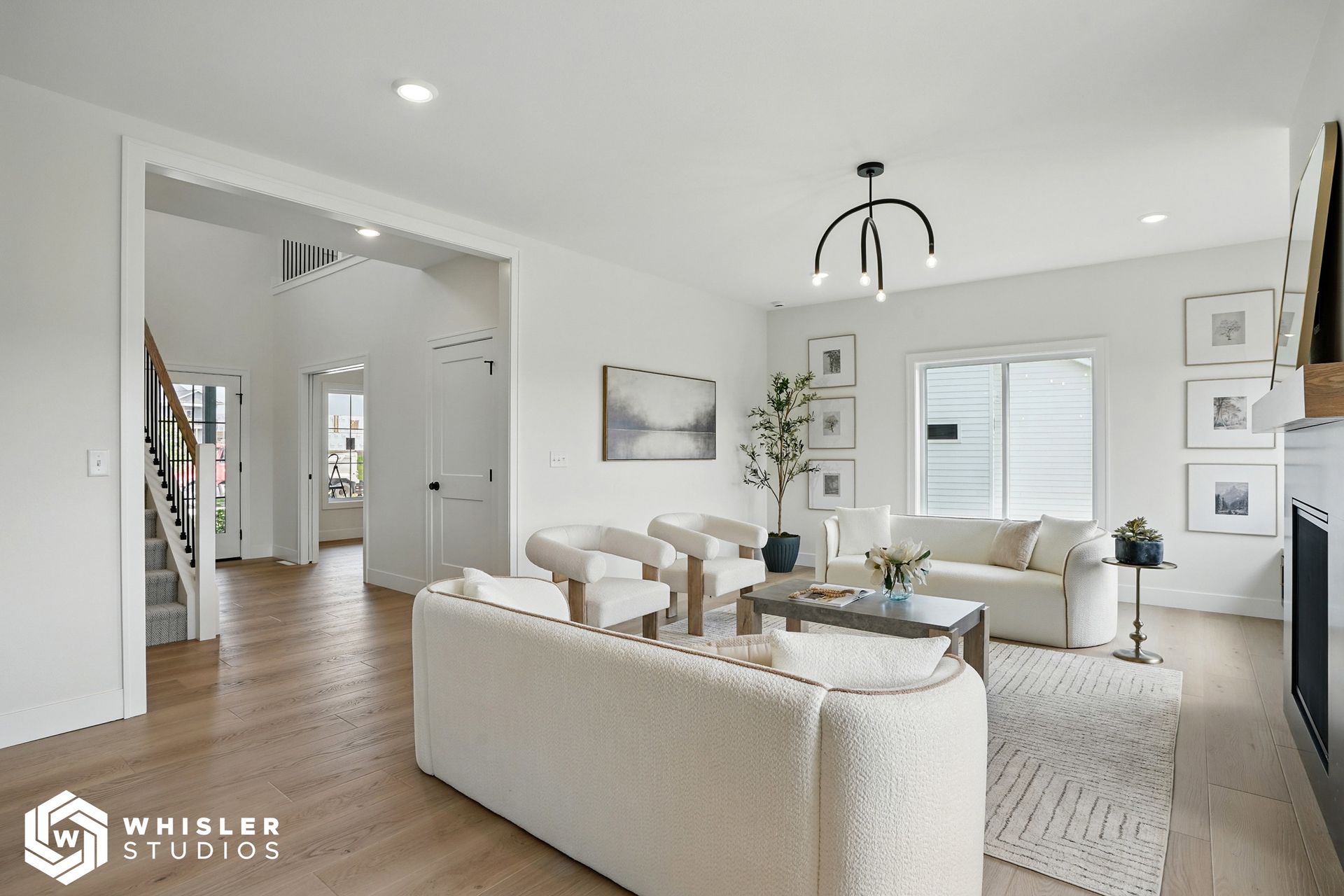 A living room with white furniture and a fireplace.