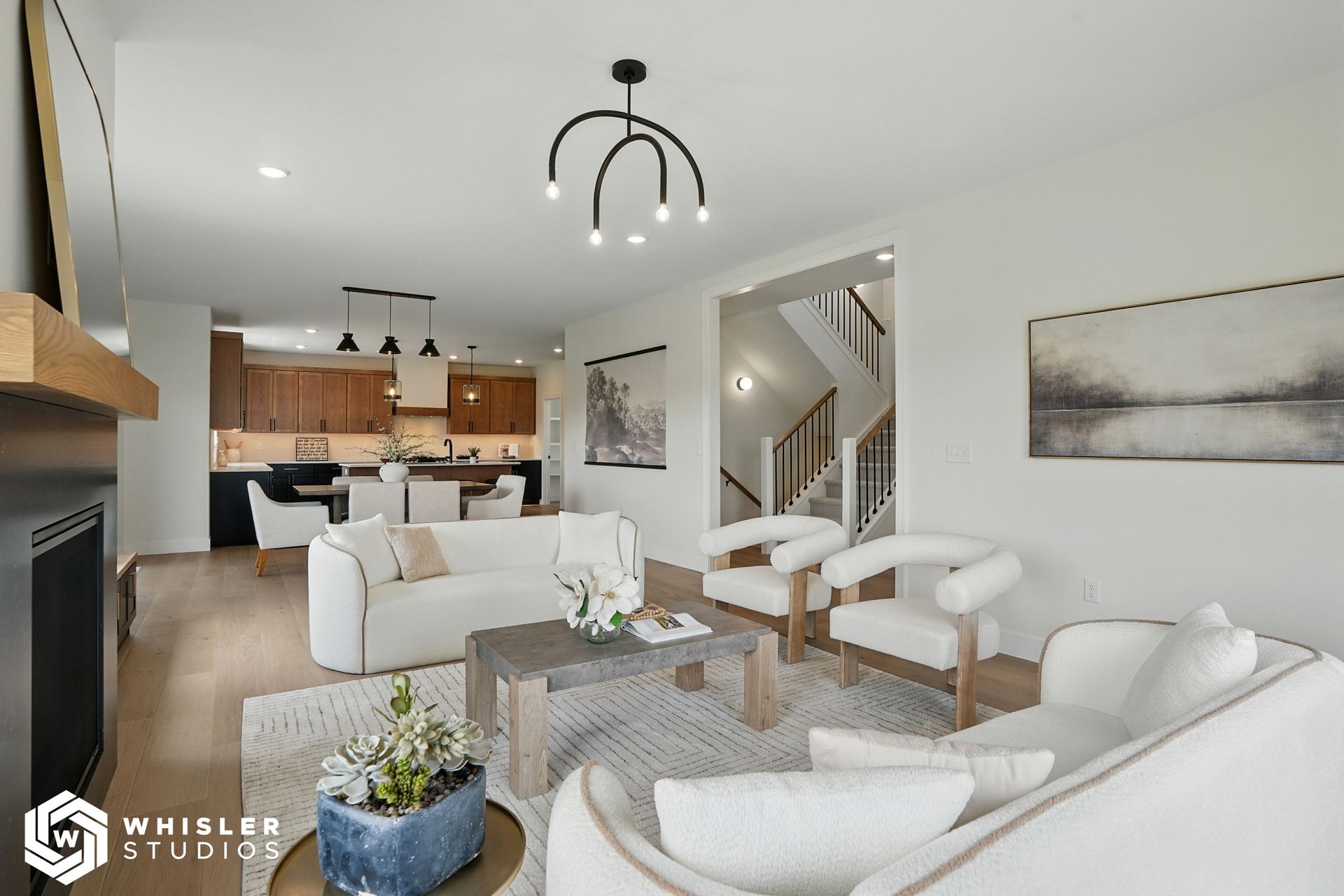 A living room with a couch, chairs, coffee table and fireplace.