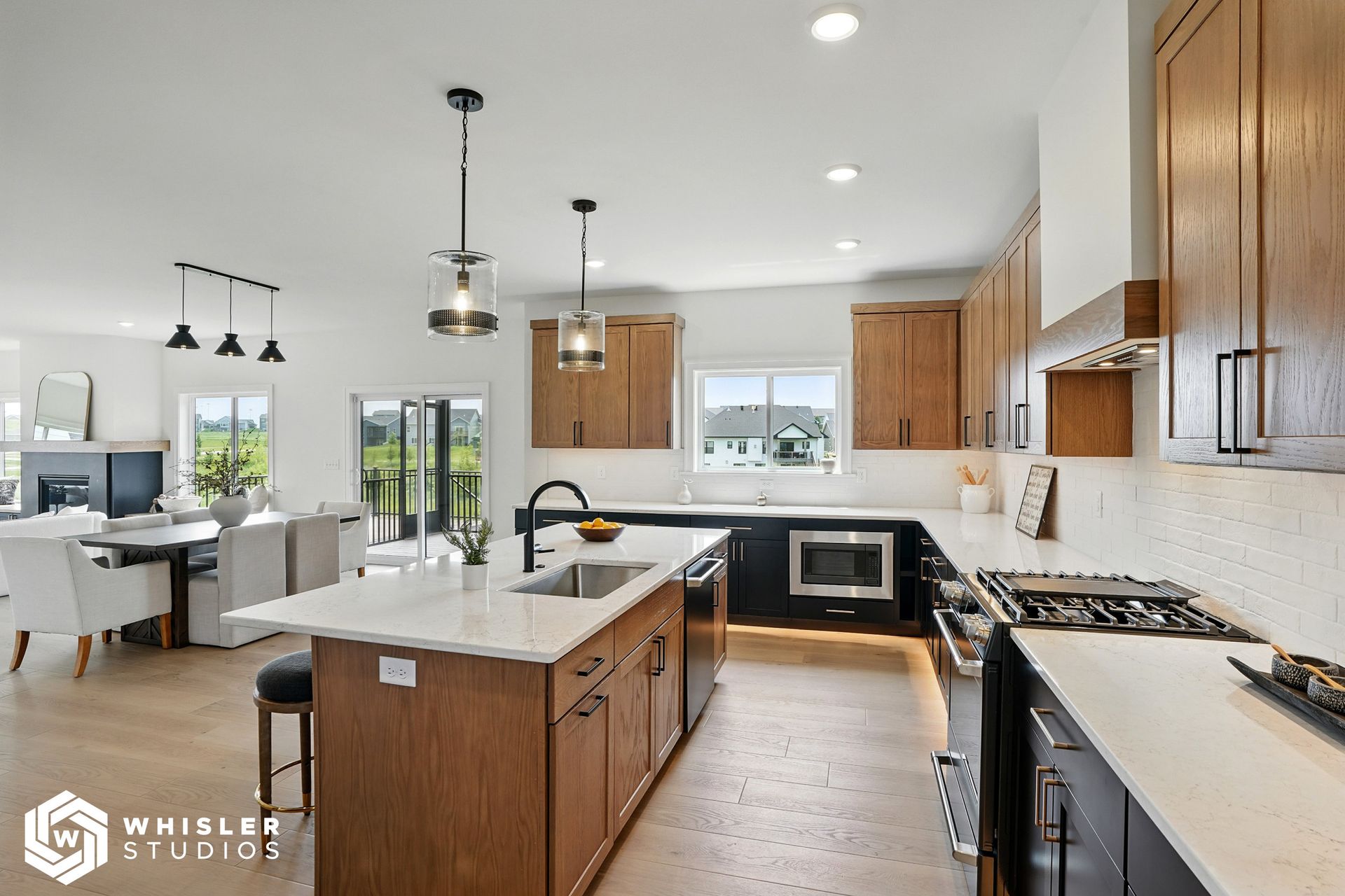 A kitchen with wooden cabinets, white counter tops, stainless steel appliances and a large island.