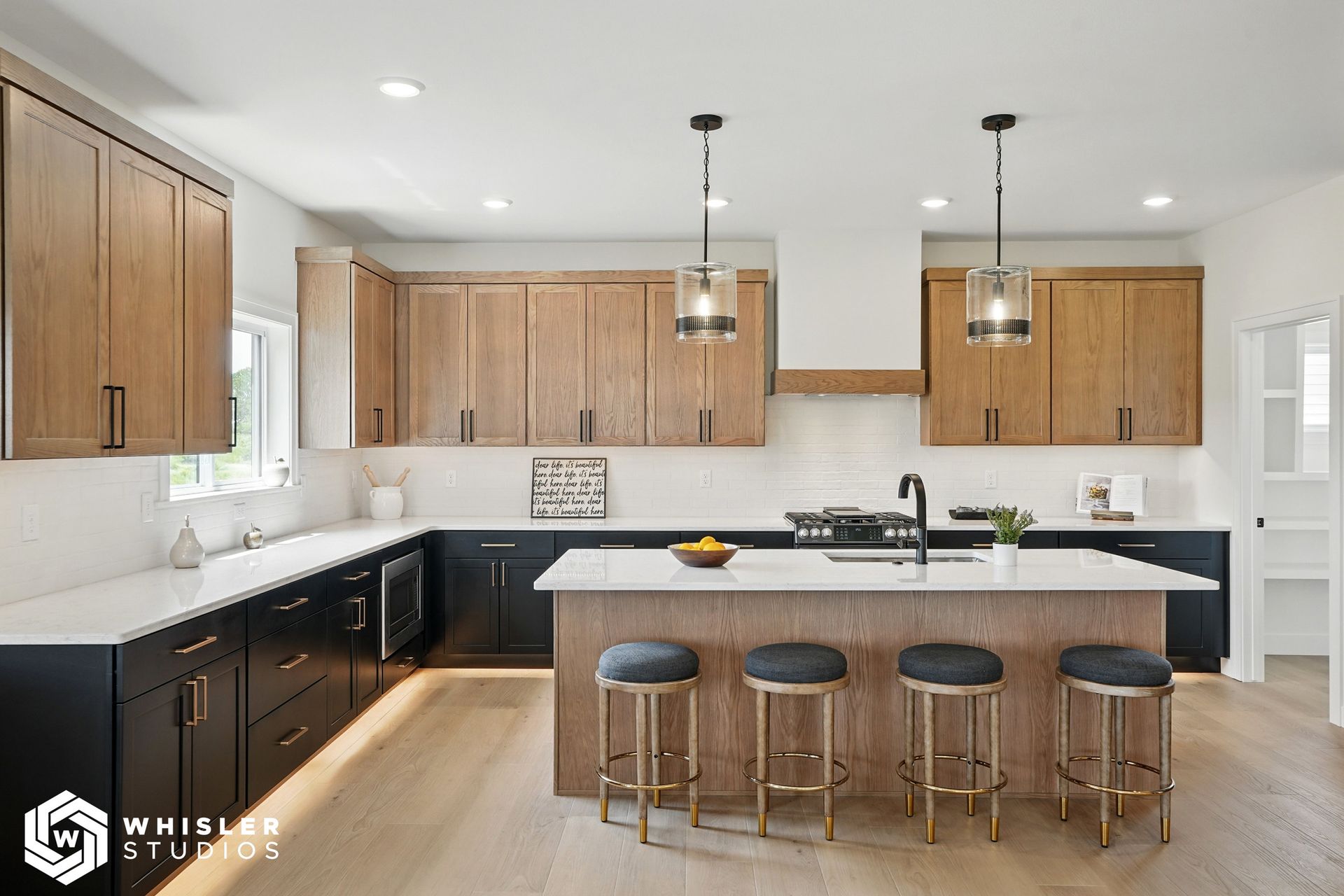 A kitchen with wooden cabinets, white counter tops, and a large island.