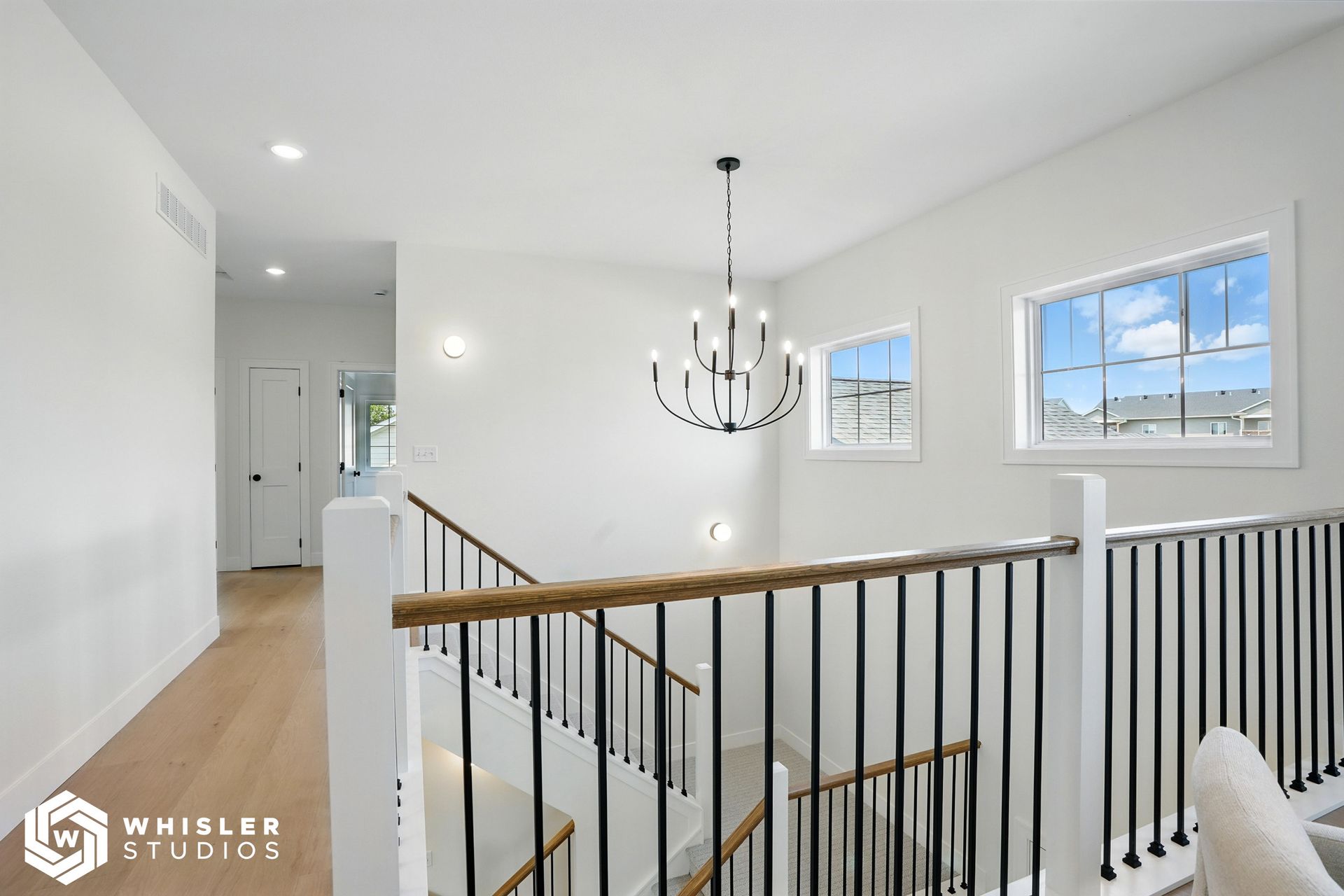 A picture of a staircase in a house with a chandelier hanging from the ceiling.