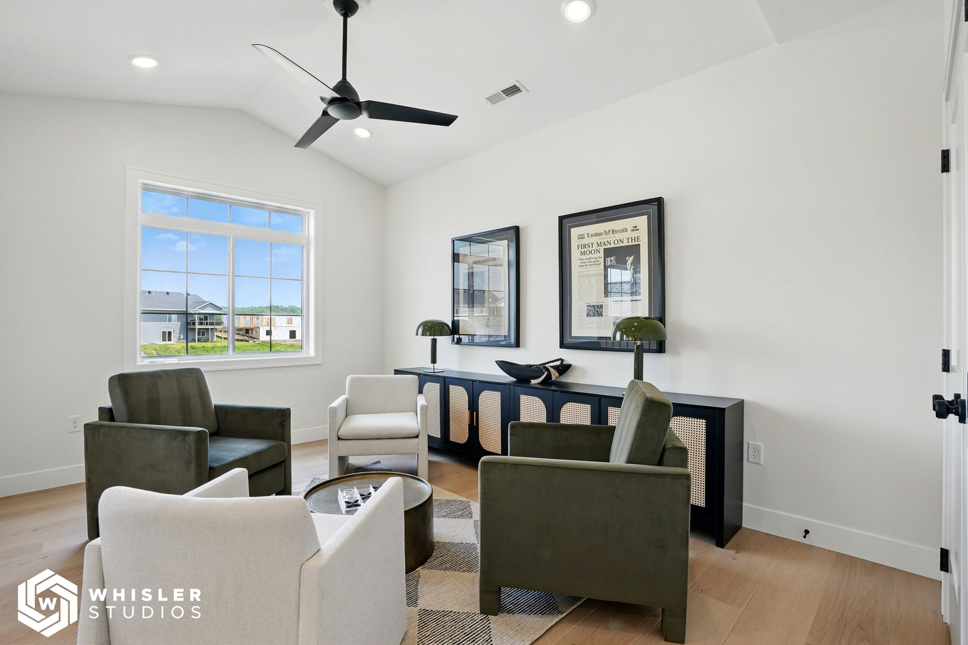 A living room with two chairs and a ceiling fan