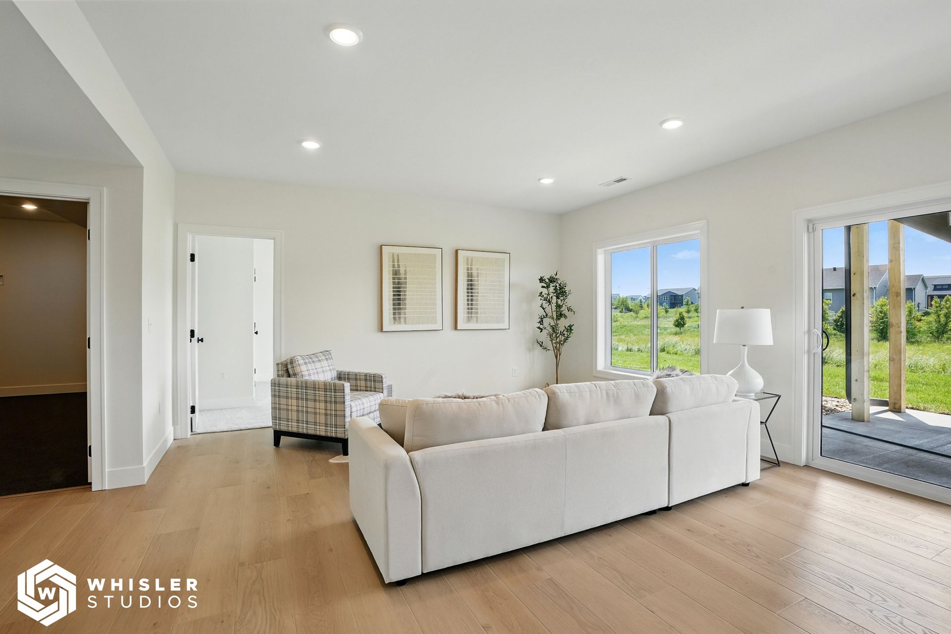 A living room with a white couch, chair, and sliding glass doors.