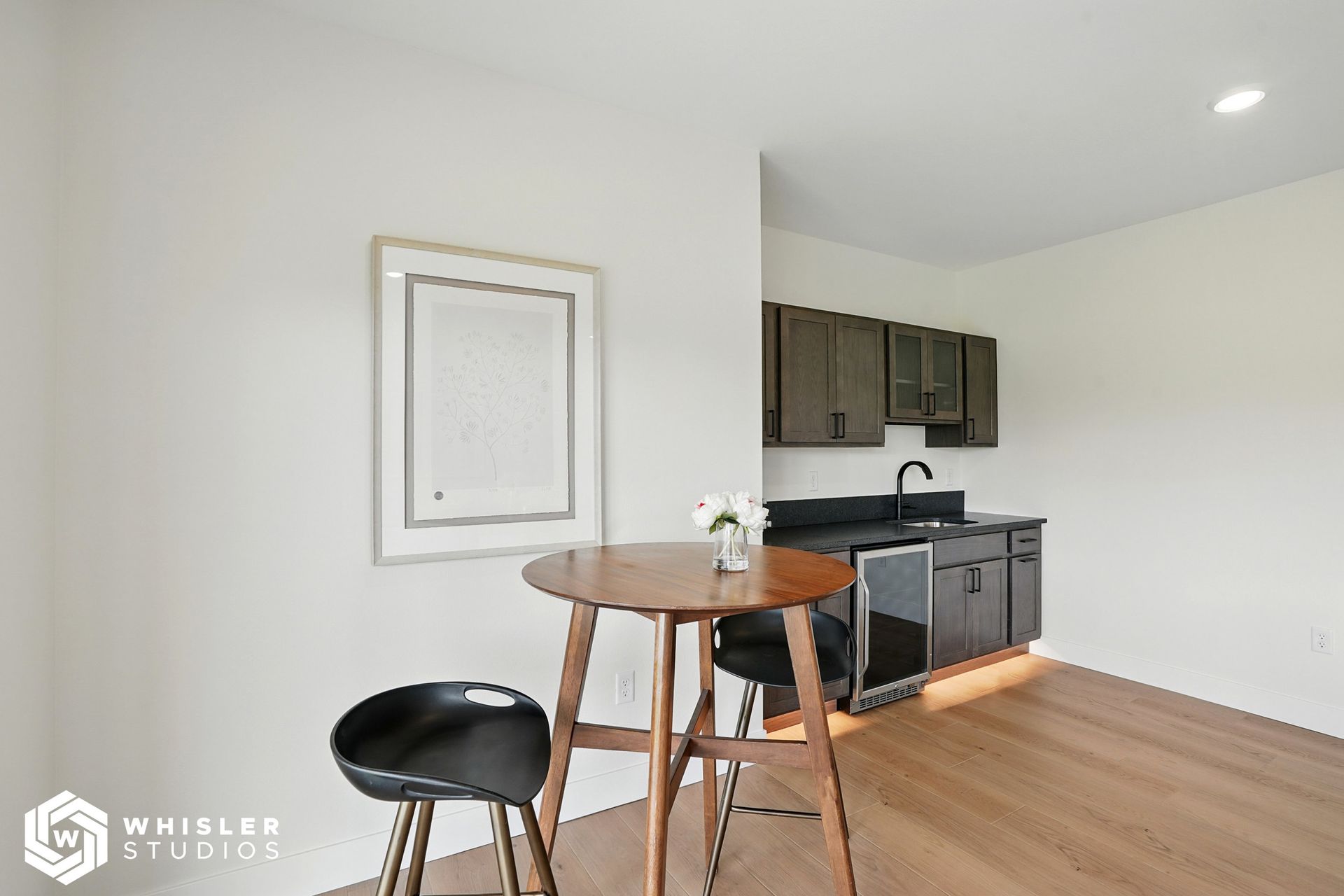 A kitchen with a table and chairs and a picture on the wall