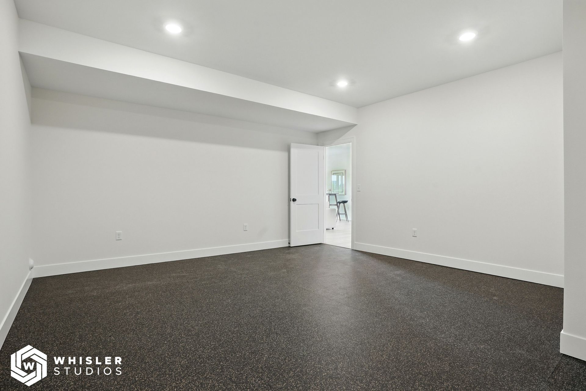 An empty room with a carpeted floor and white walls.
