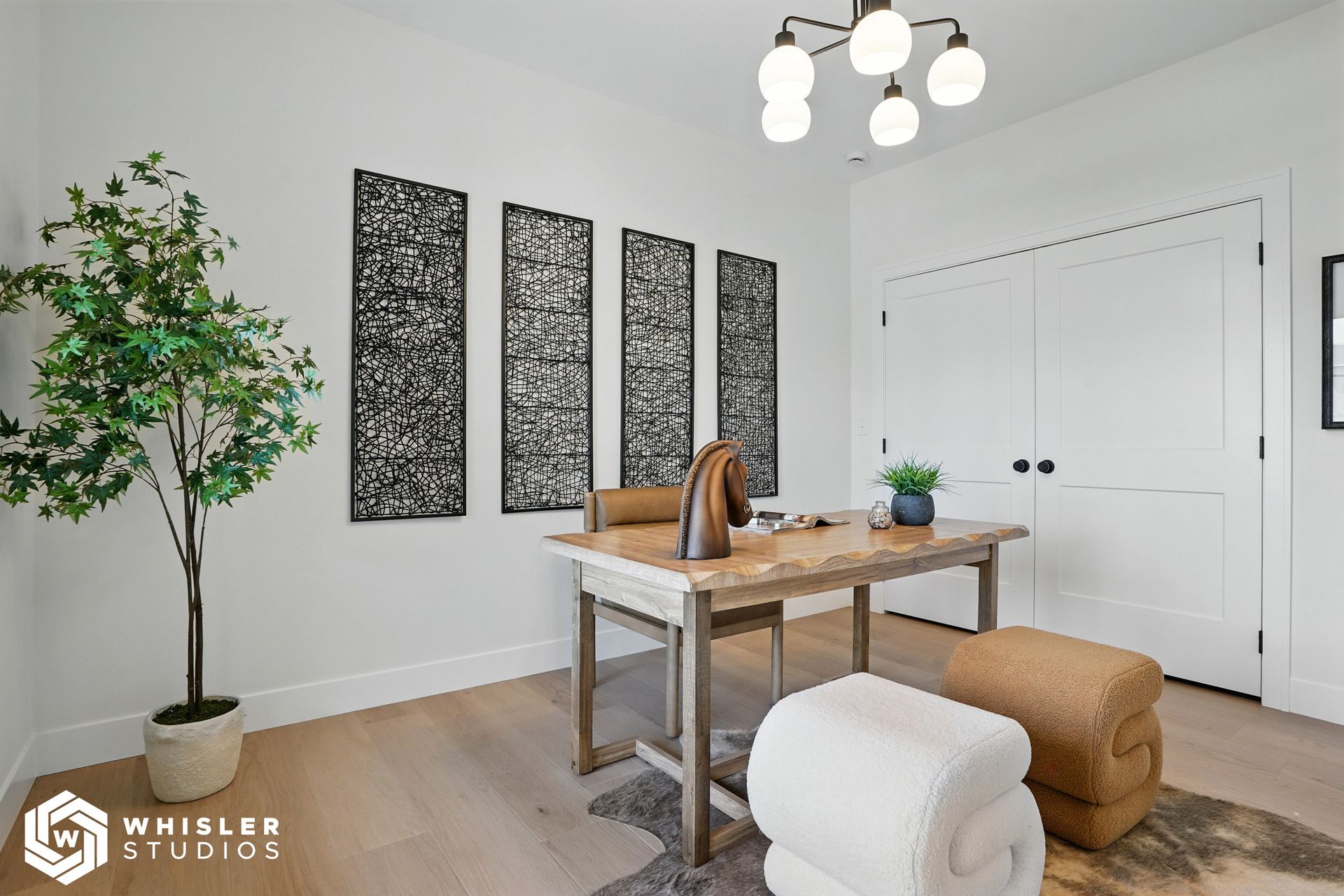 A home office with a desk, chairs, and a plant.