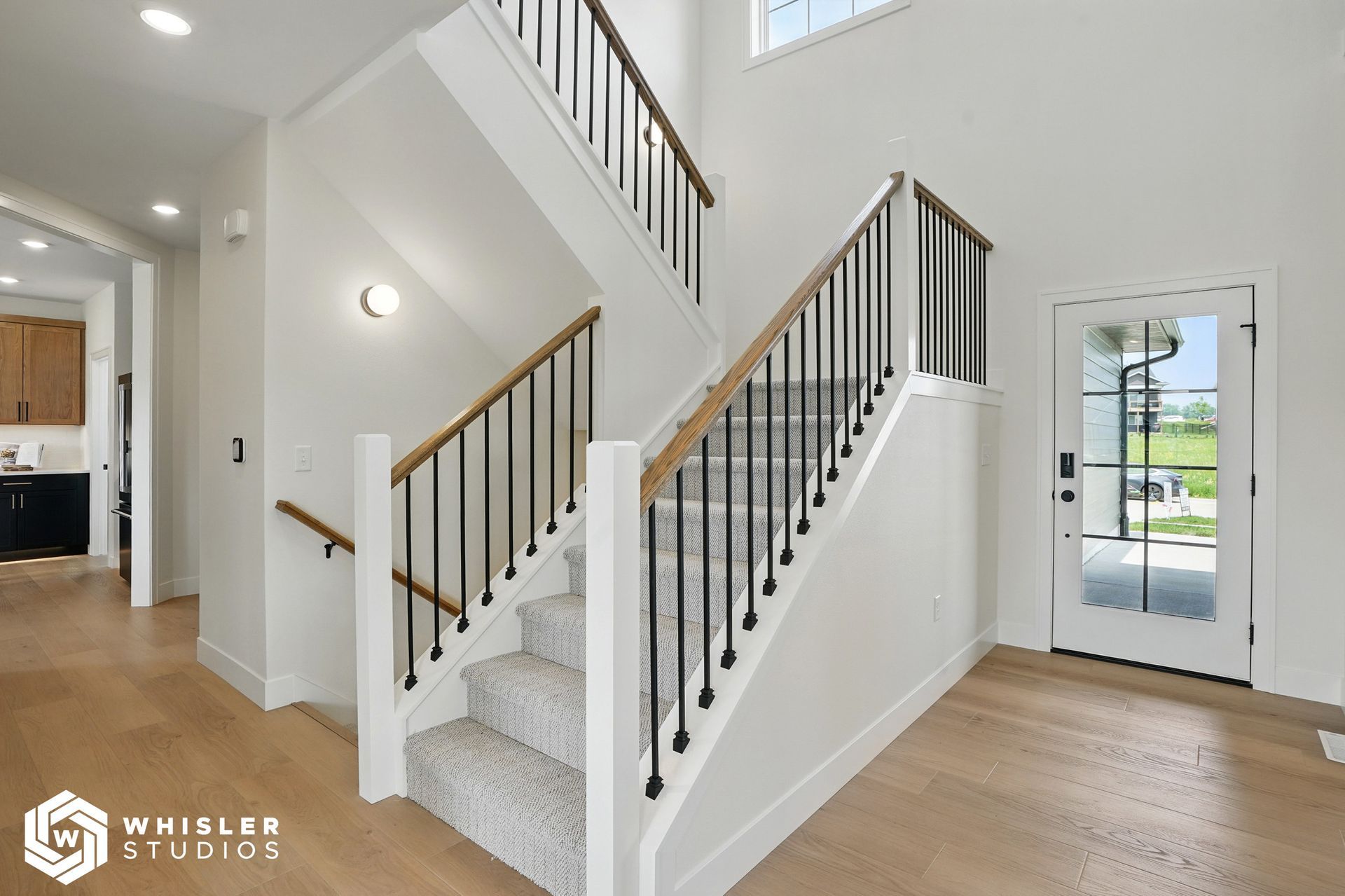 A white staircase with a black railing in a house.