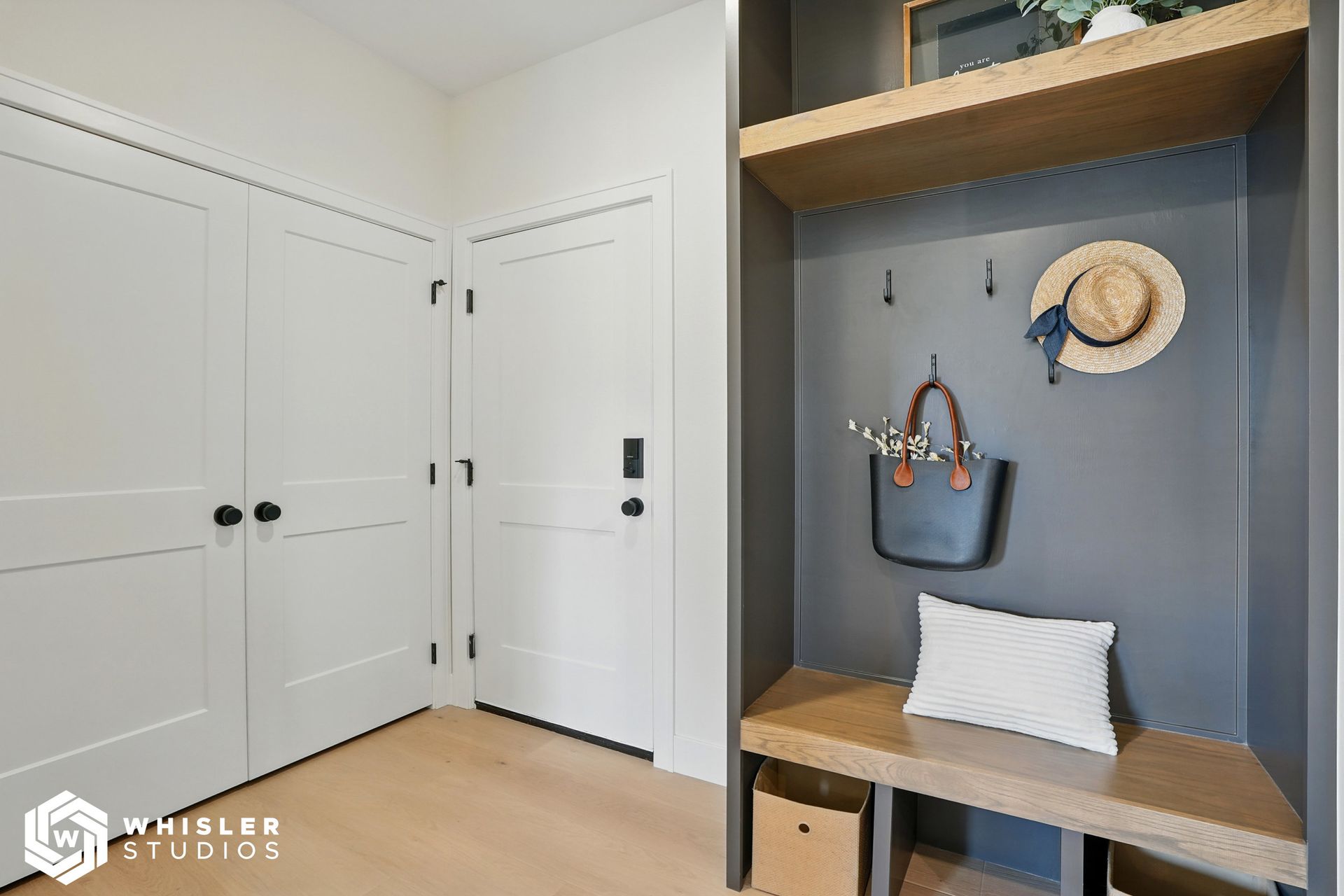 A hallway with a bench and a hat hanging on the wall.
