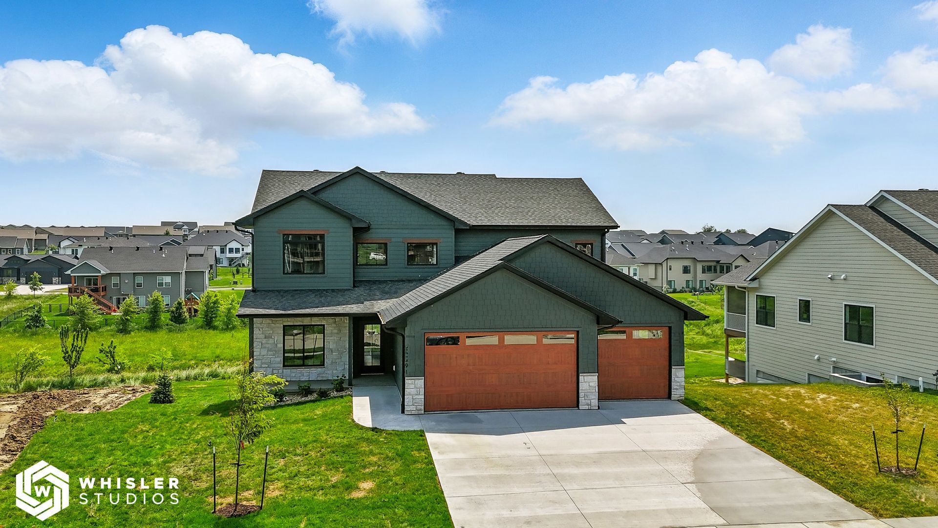 An aerial view of a large house with two garages in a residential area.