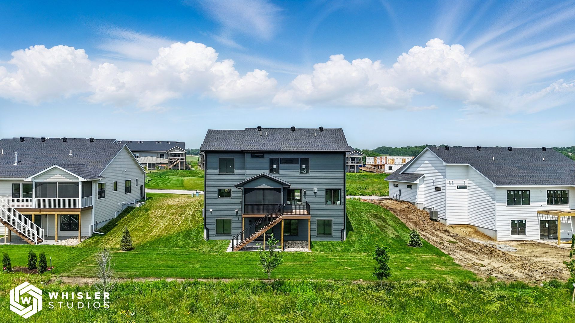 A group of houses sitting on top of a lush green field.