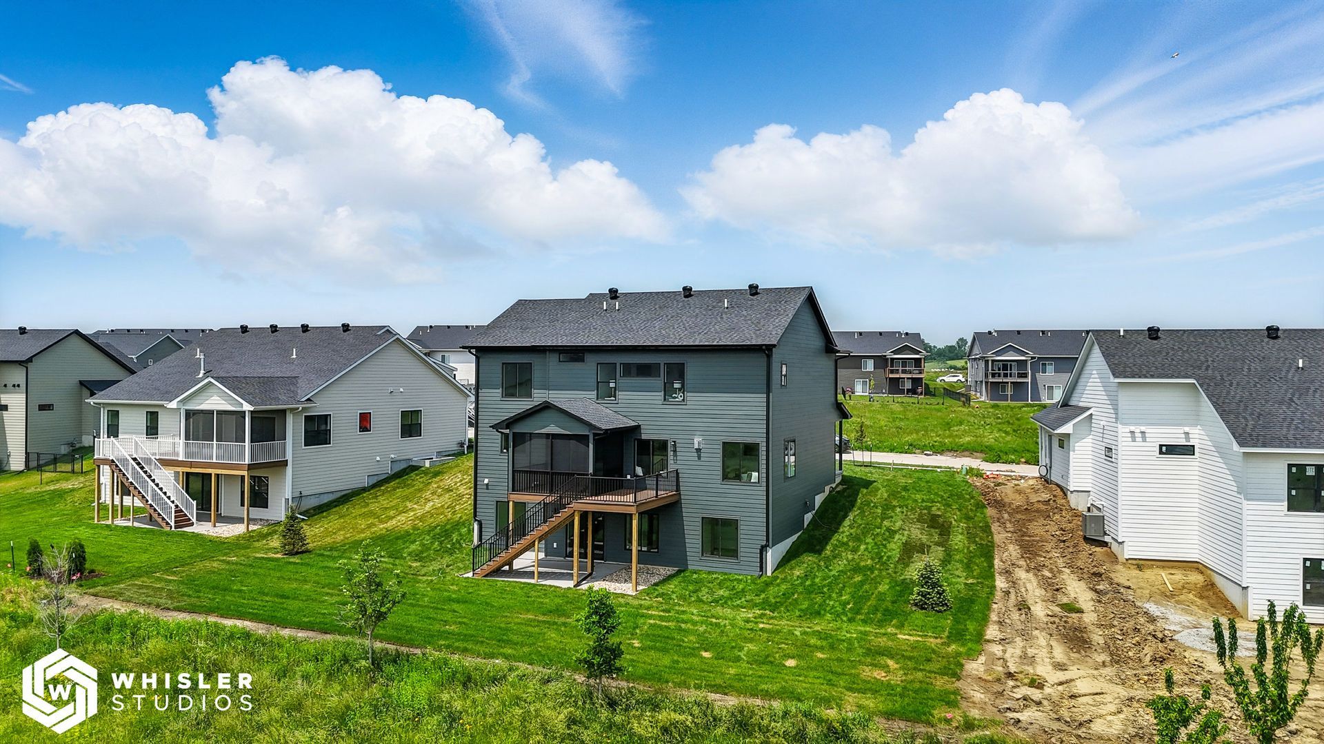 A row of houses are sitting on top of a lush green hillside.