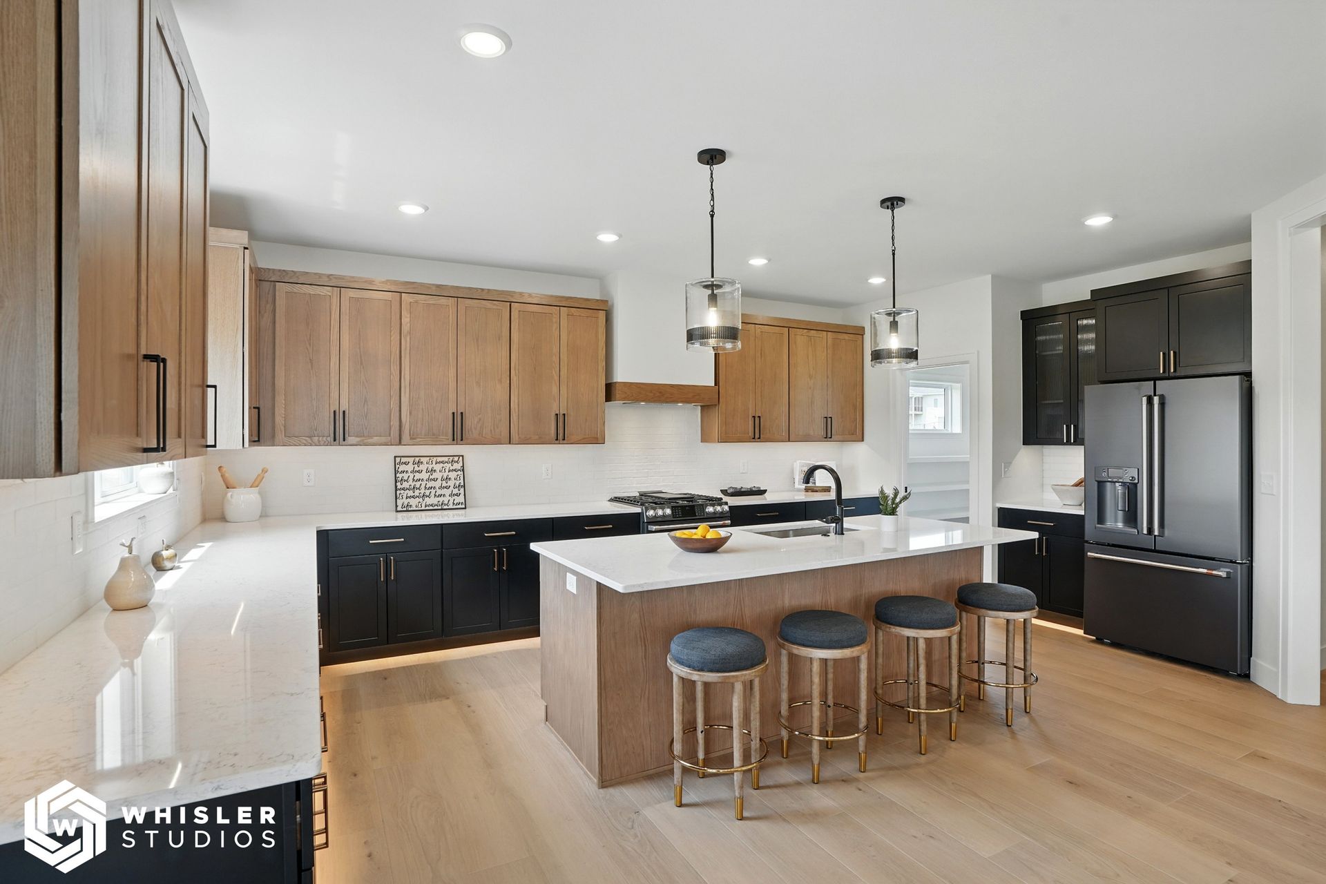 A kitchen with black cabinets, white countertops, and a large island.