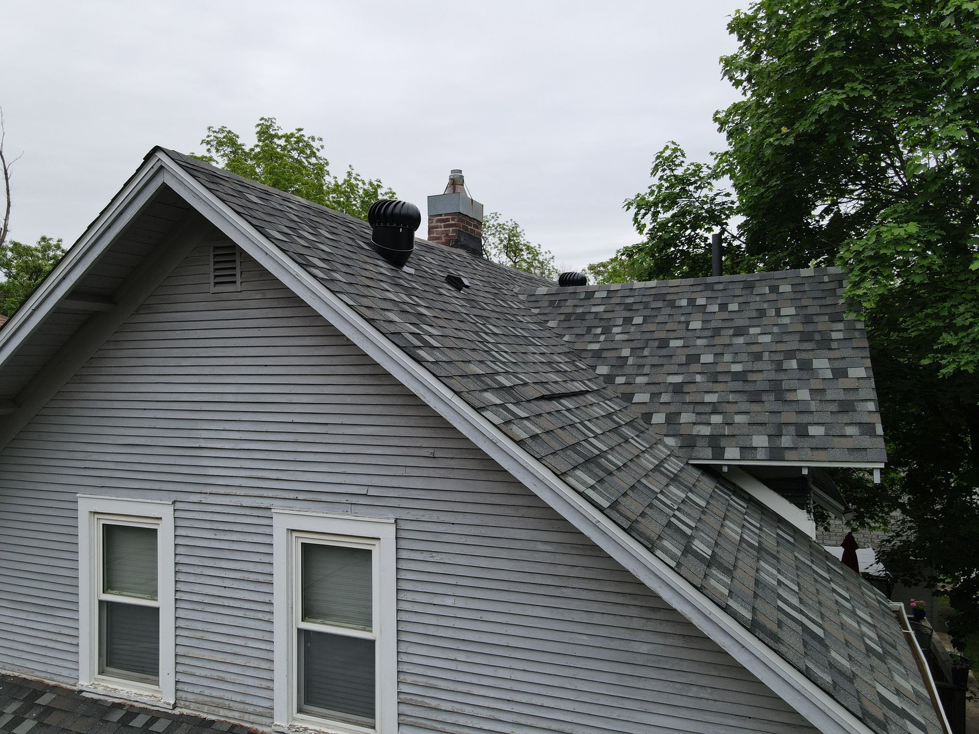 A white house with a gray roof and two windows