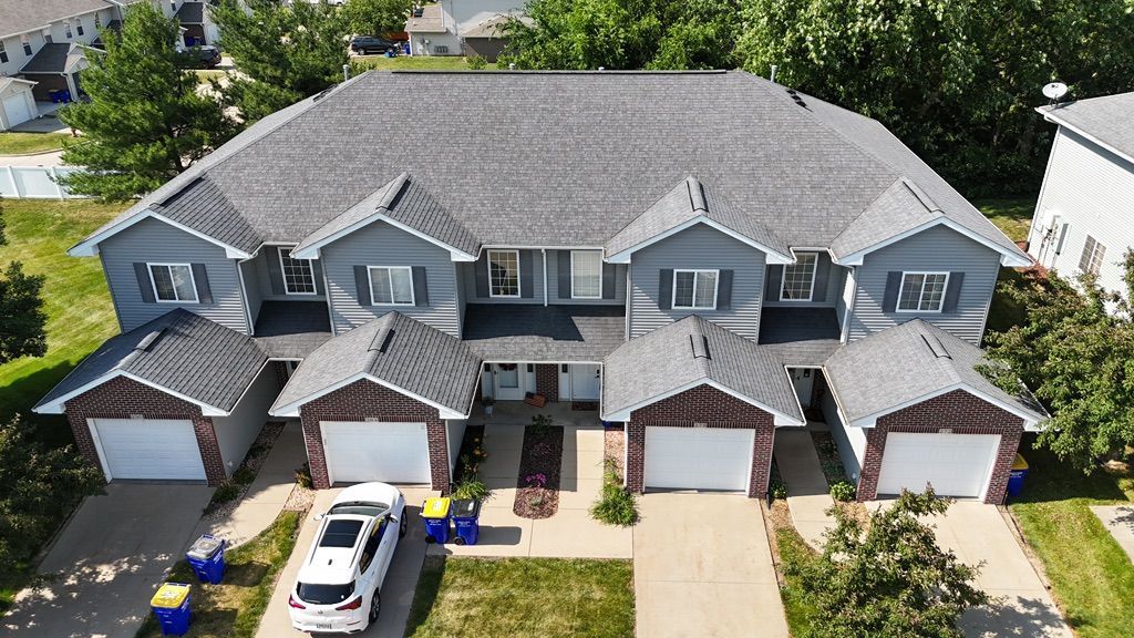 An aerial view of a row of houses with cars parked in front of them