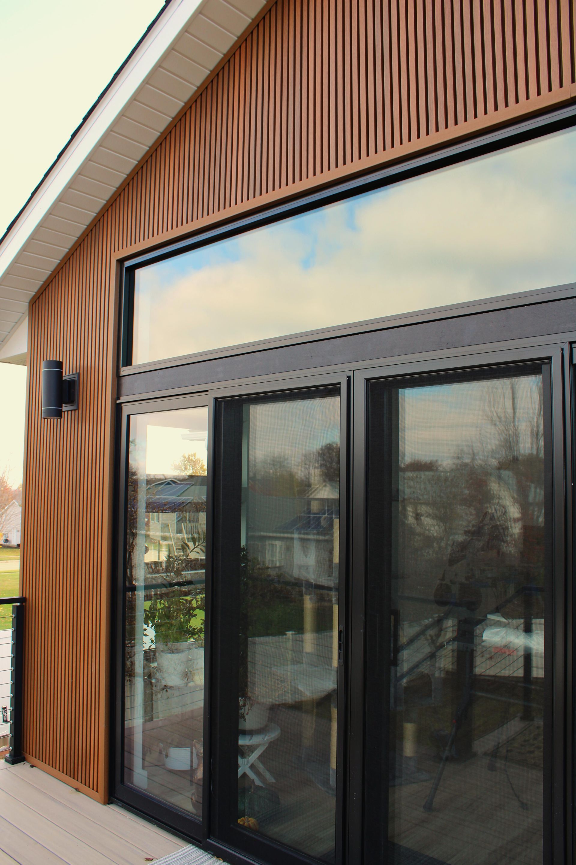 A house with a large window and sliding glass doors.