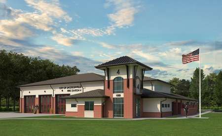 Fire station building with brick accents, flag pole, and three vehicle bays.
