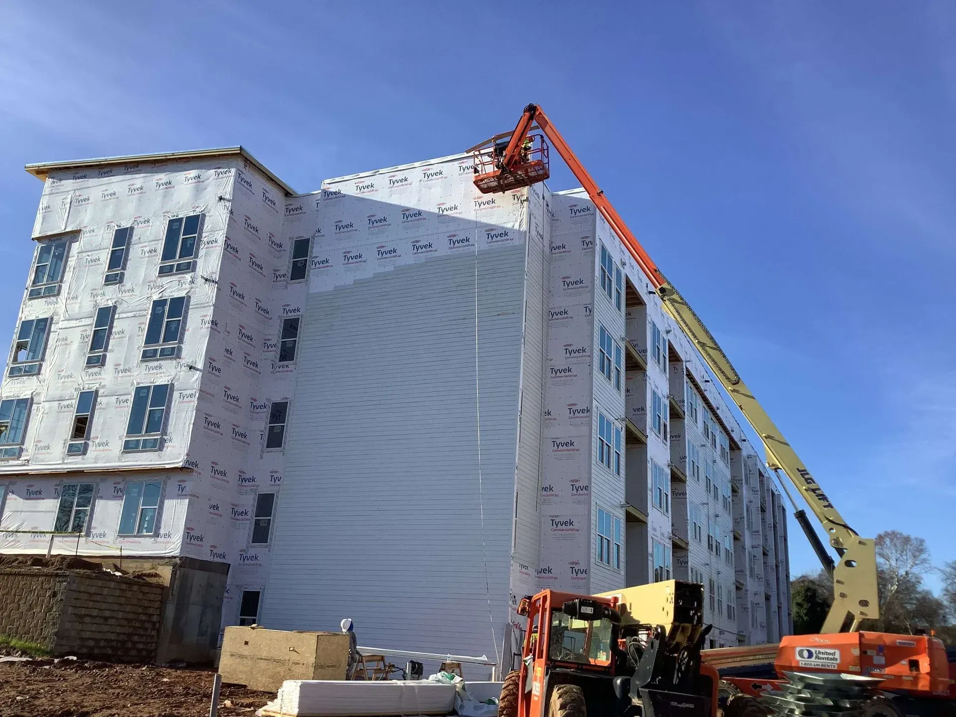 A large building is being built with a crane on top of it.