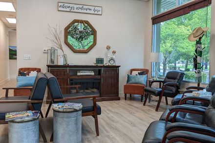 A waiting room with lots of chairs and a fireplace.