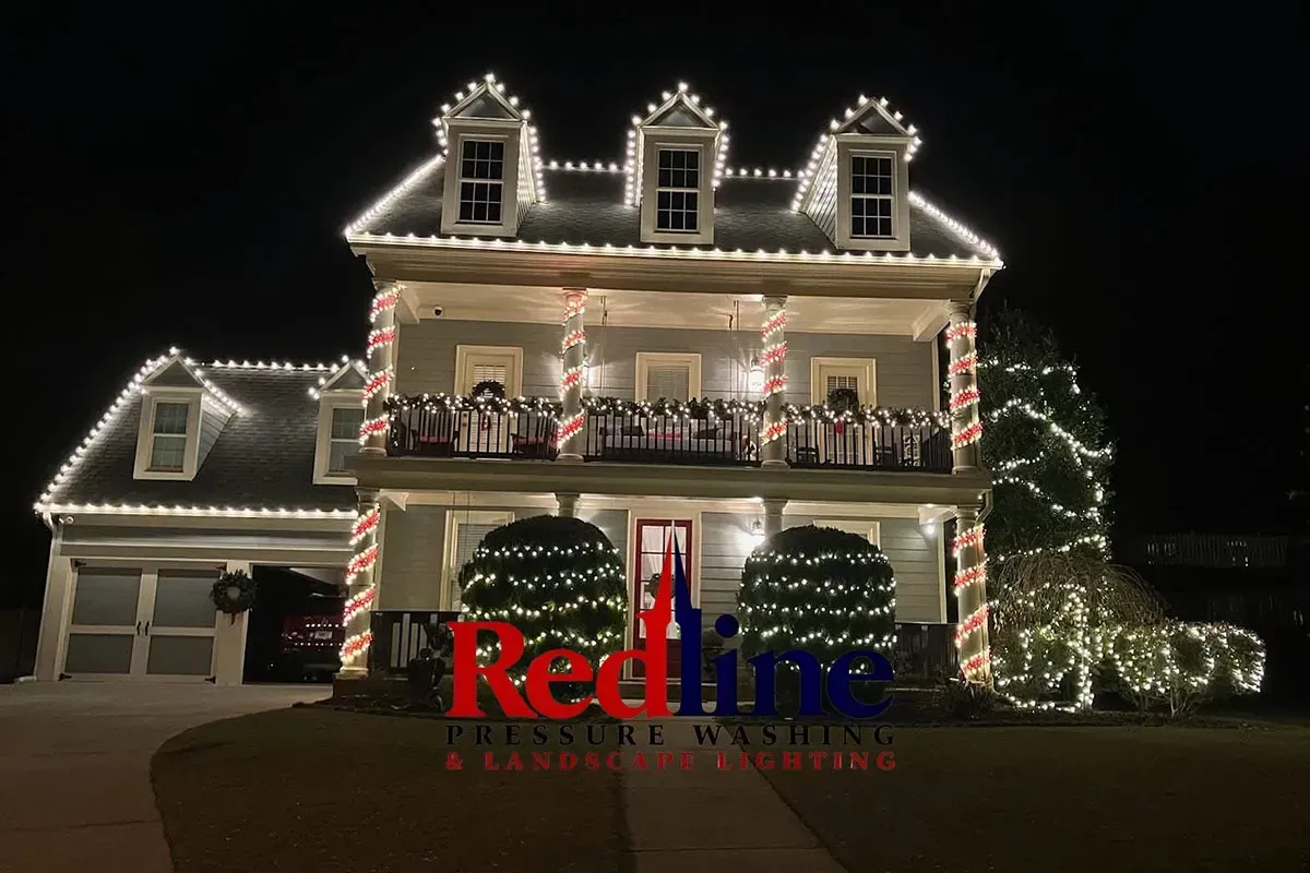 House outlined in white Christmas lights with red-and-white candy cane columns at night
