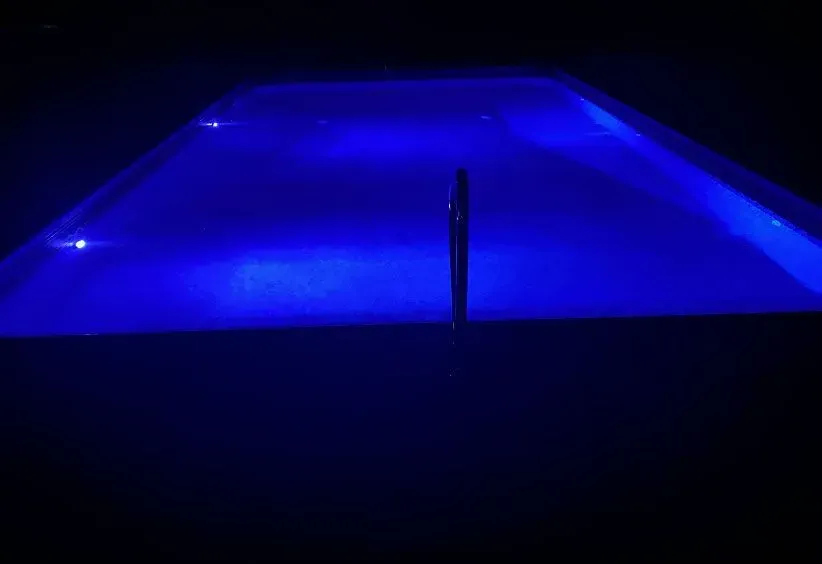 Blue-lit rectangular surface with a dark object in the center, likely outdoors at night.
