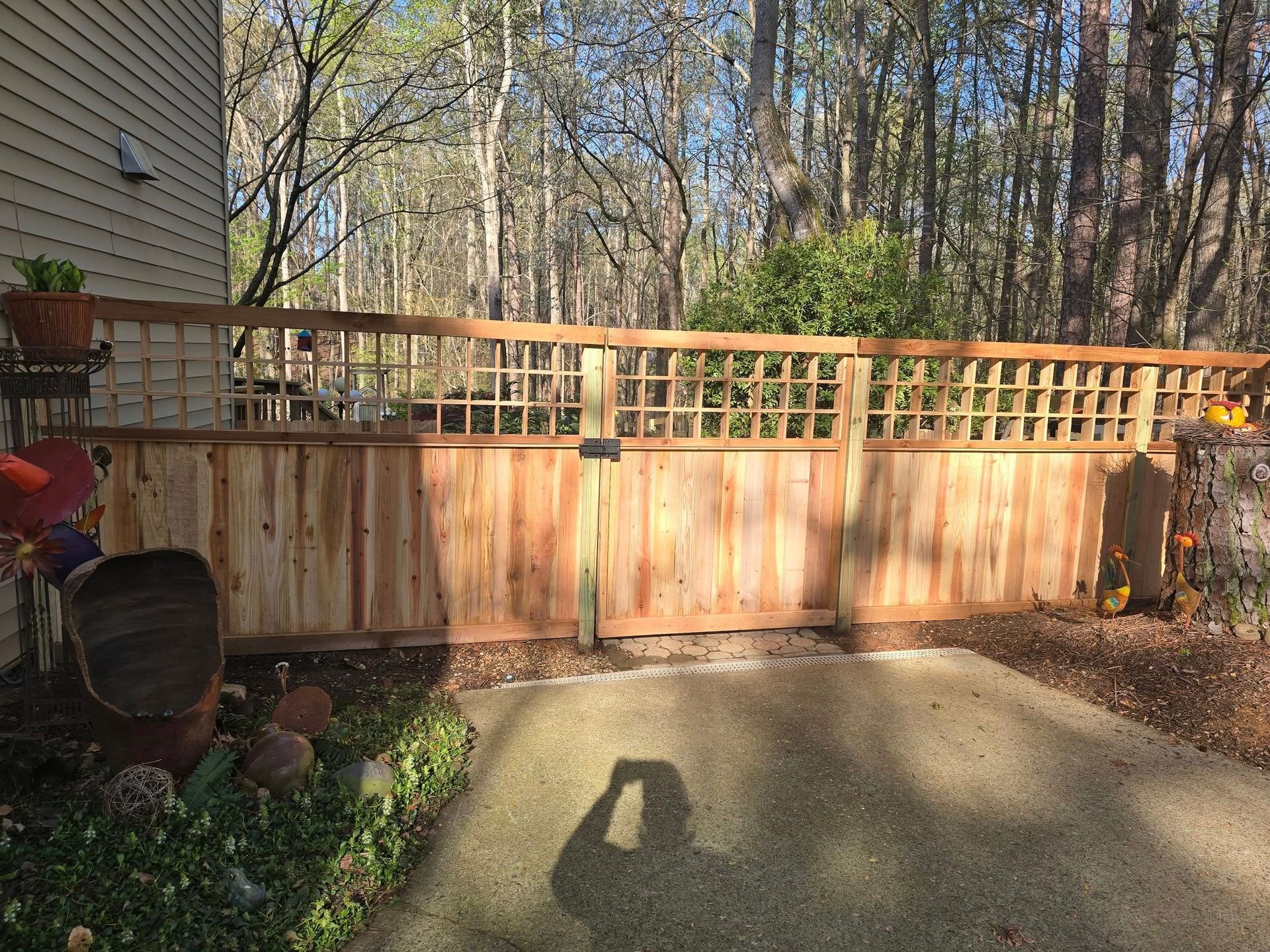 Wooden fence with lattice detail in a backyard setting.