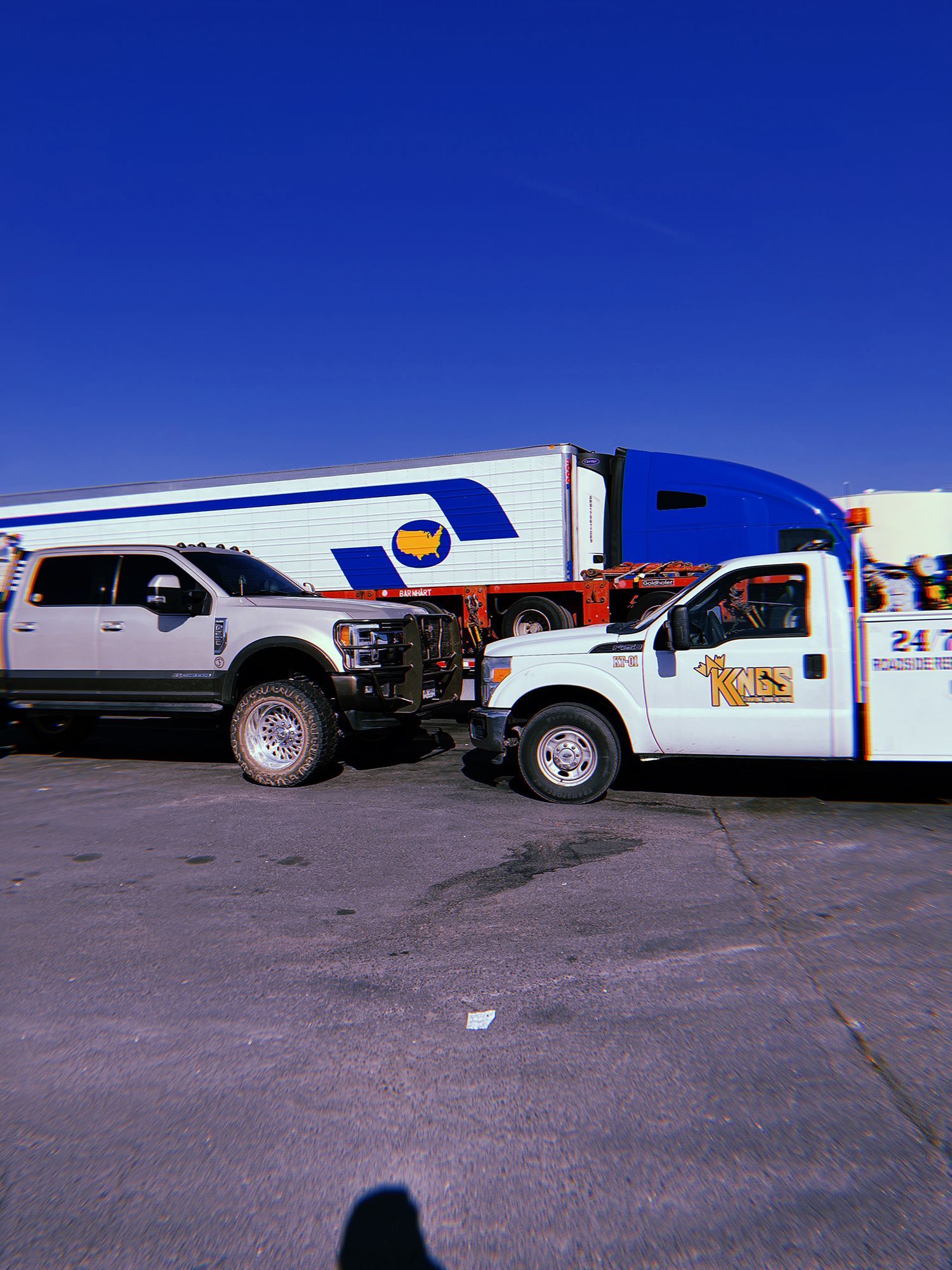 Two trucks are parked next to each other in a parking lot.